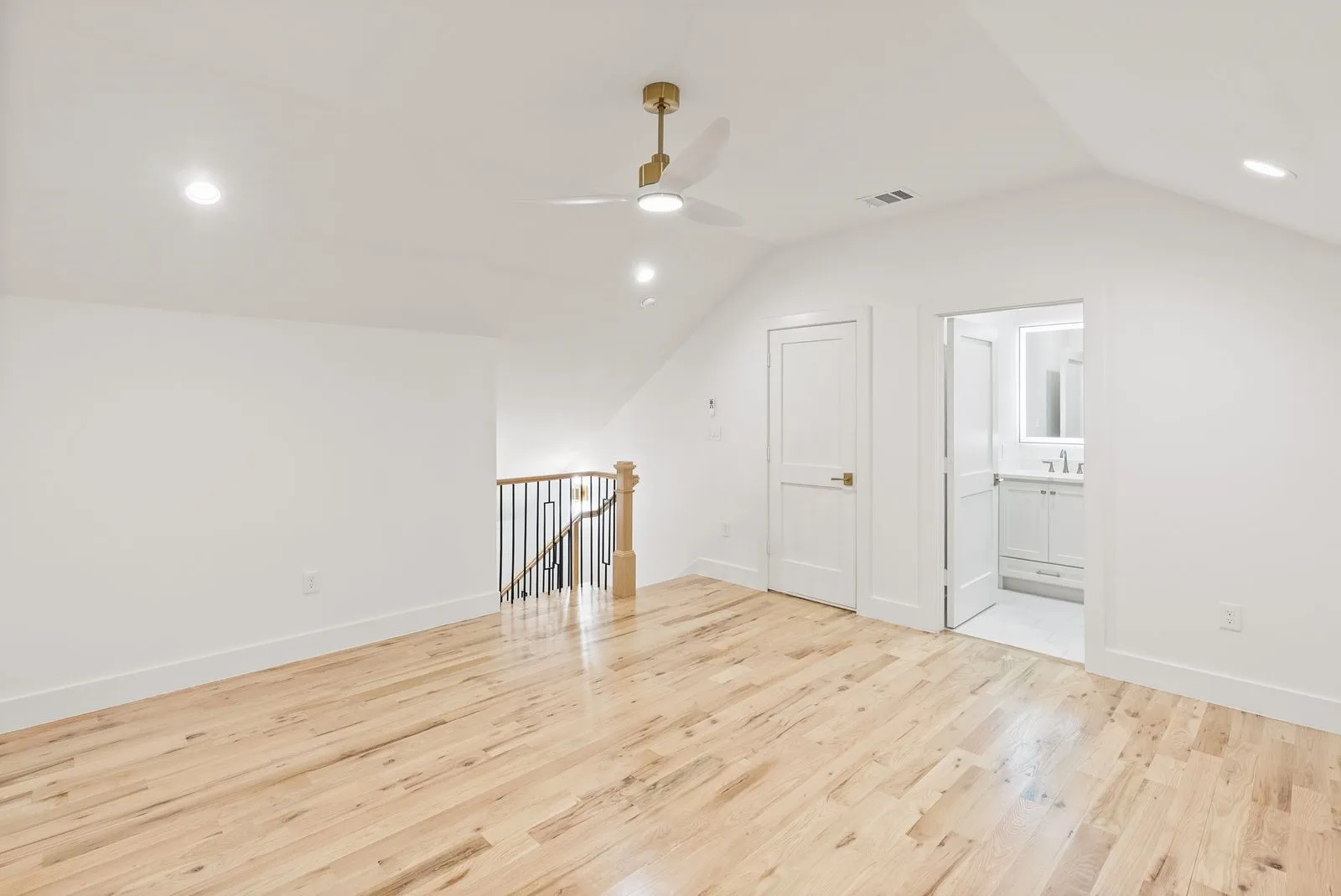 Wood-finish flooring with recessed lighting and a ceiling fan