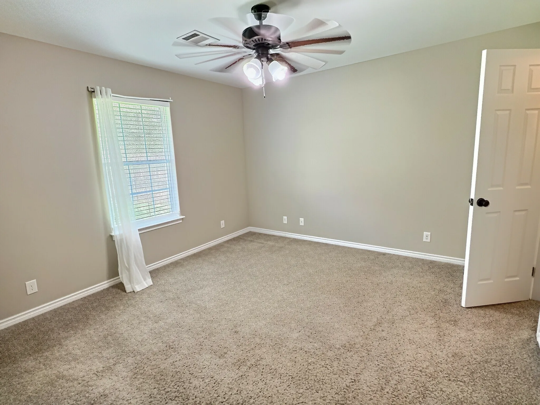 Neutral tone wall paint, carpet flooring, window with blinds, ceiling fan, and white trim