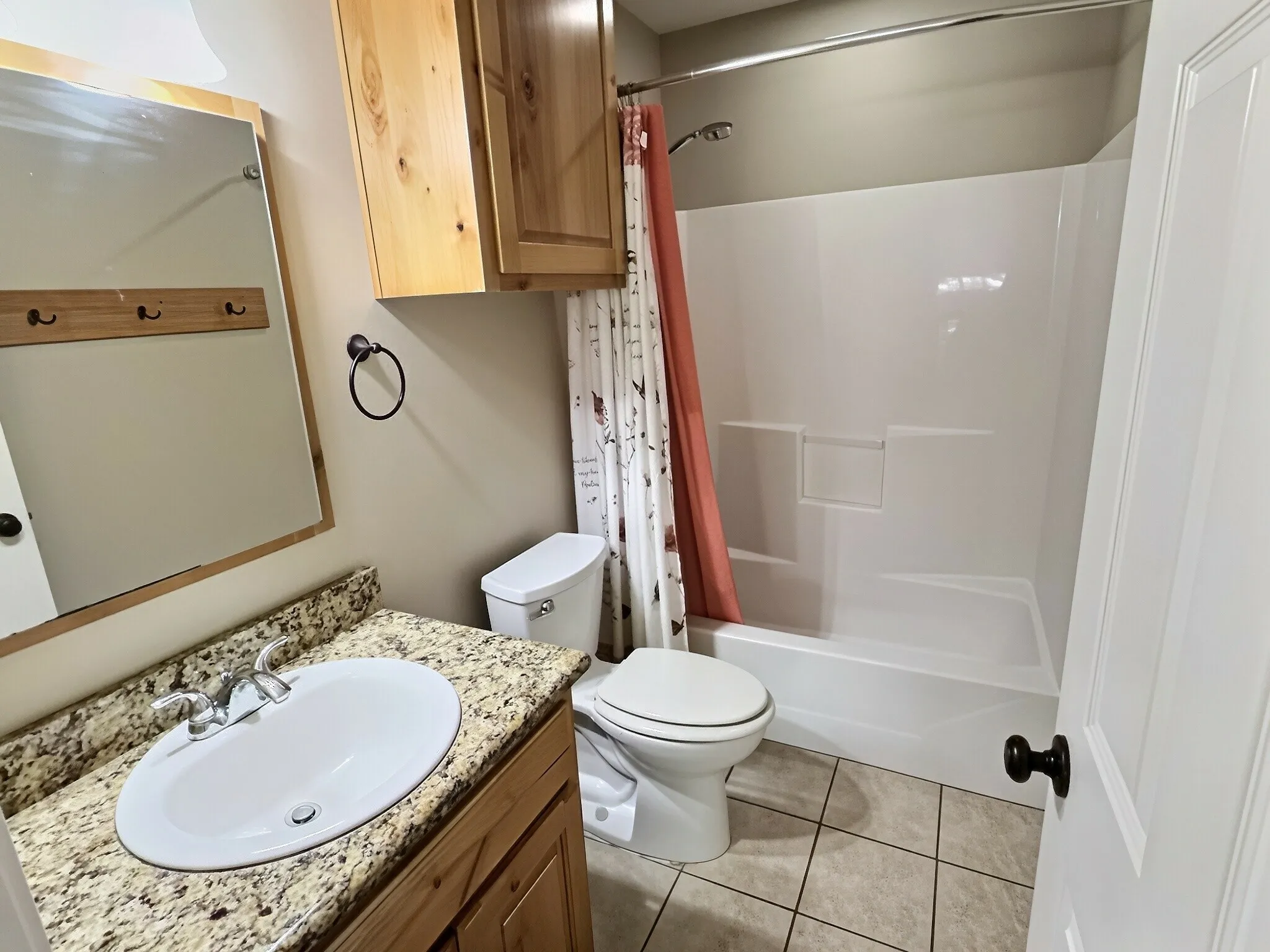 Bathroom featuring a built-in vanity with a granite-look countertop, integrated sink, and wood-finish cabinetry