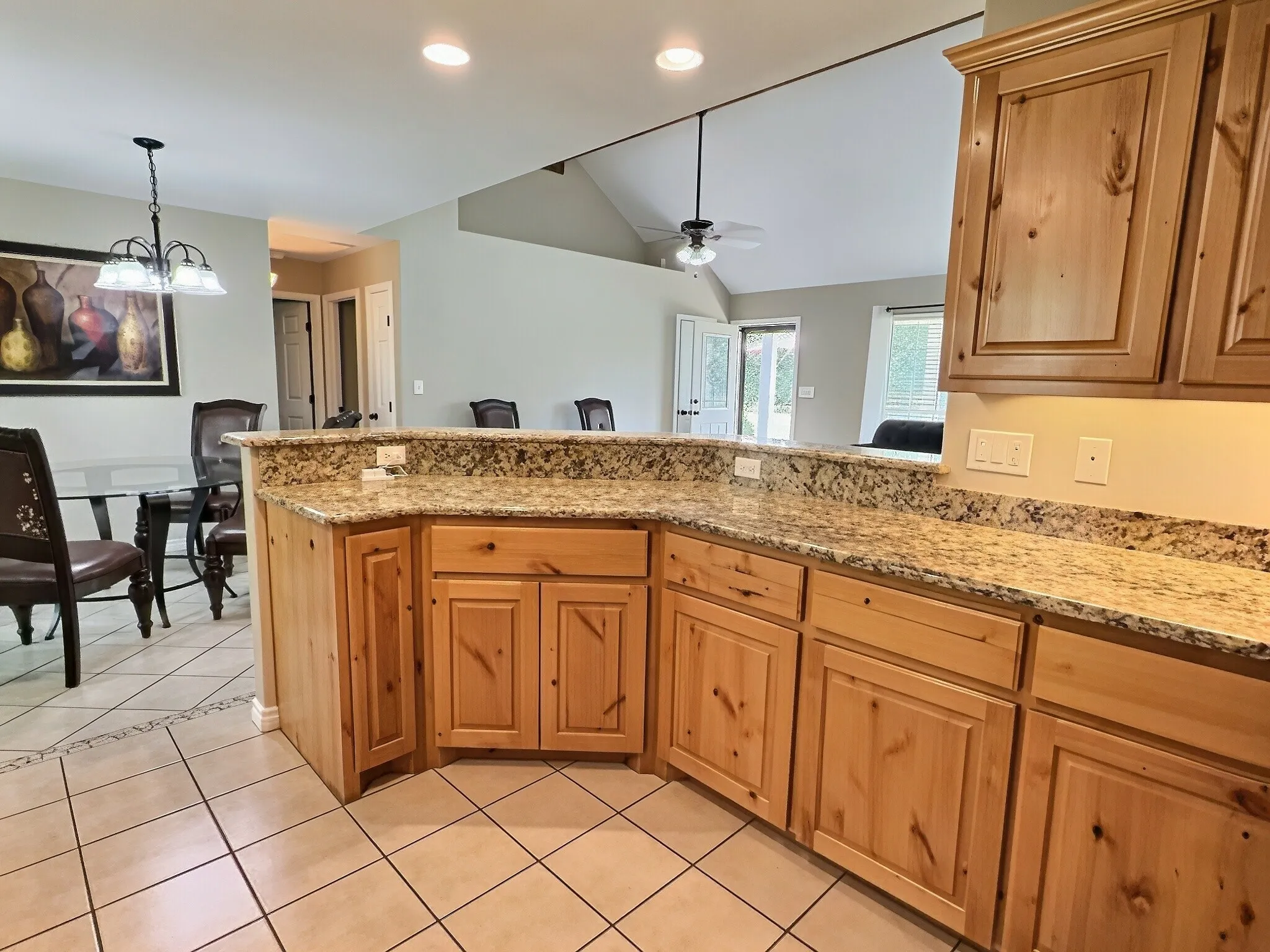 Kitchen featuring light wood cabinetry, granite countertops, and tile flooring
