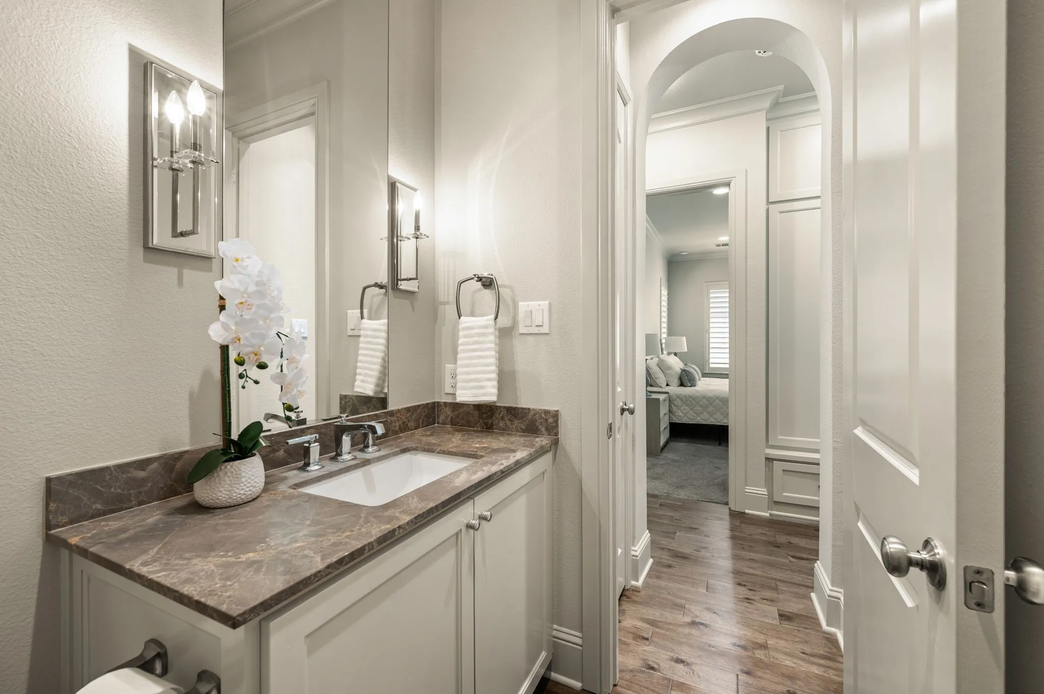 Powder room with a built-in sink, polished chrome faucet, and stone-finish countertop