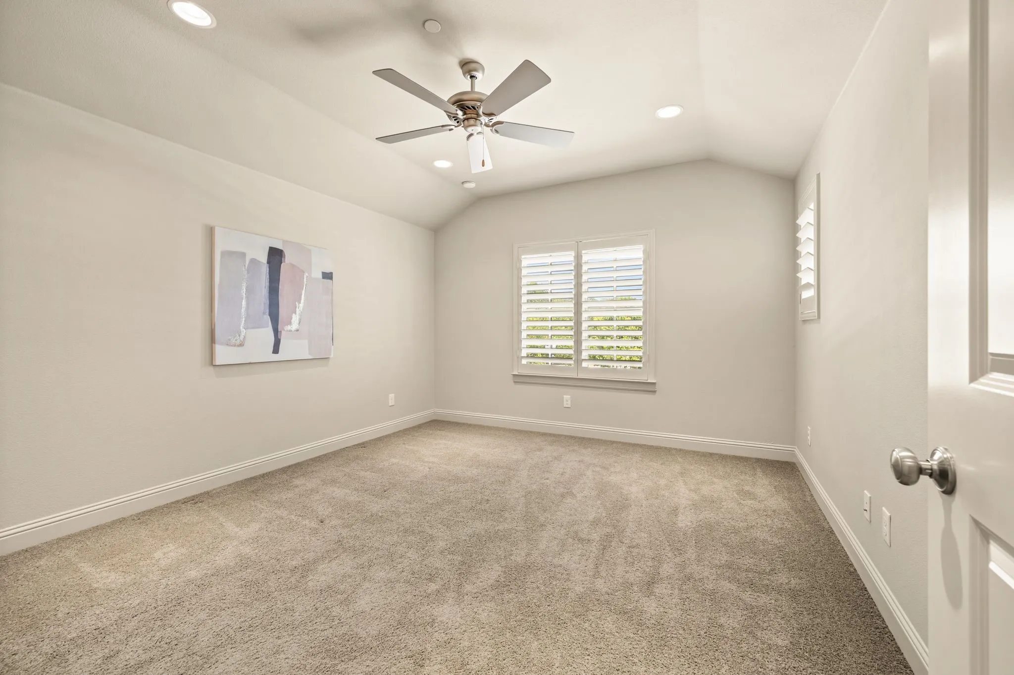 Vaulted ceiling featuring a ceiling fan with integrated lighting, recessed lighting, plantation shutters, and soft carpeting