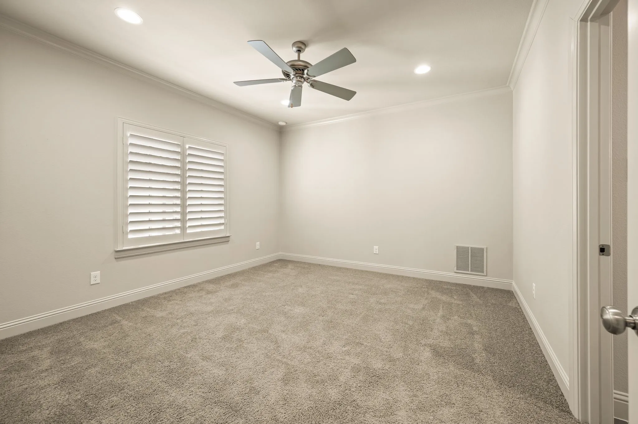 Recessed lighting, crown molding, ceiling fan, plantation shutters, and carpet flooring