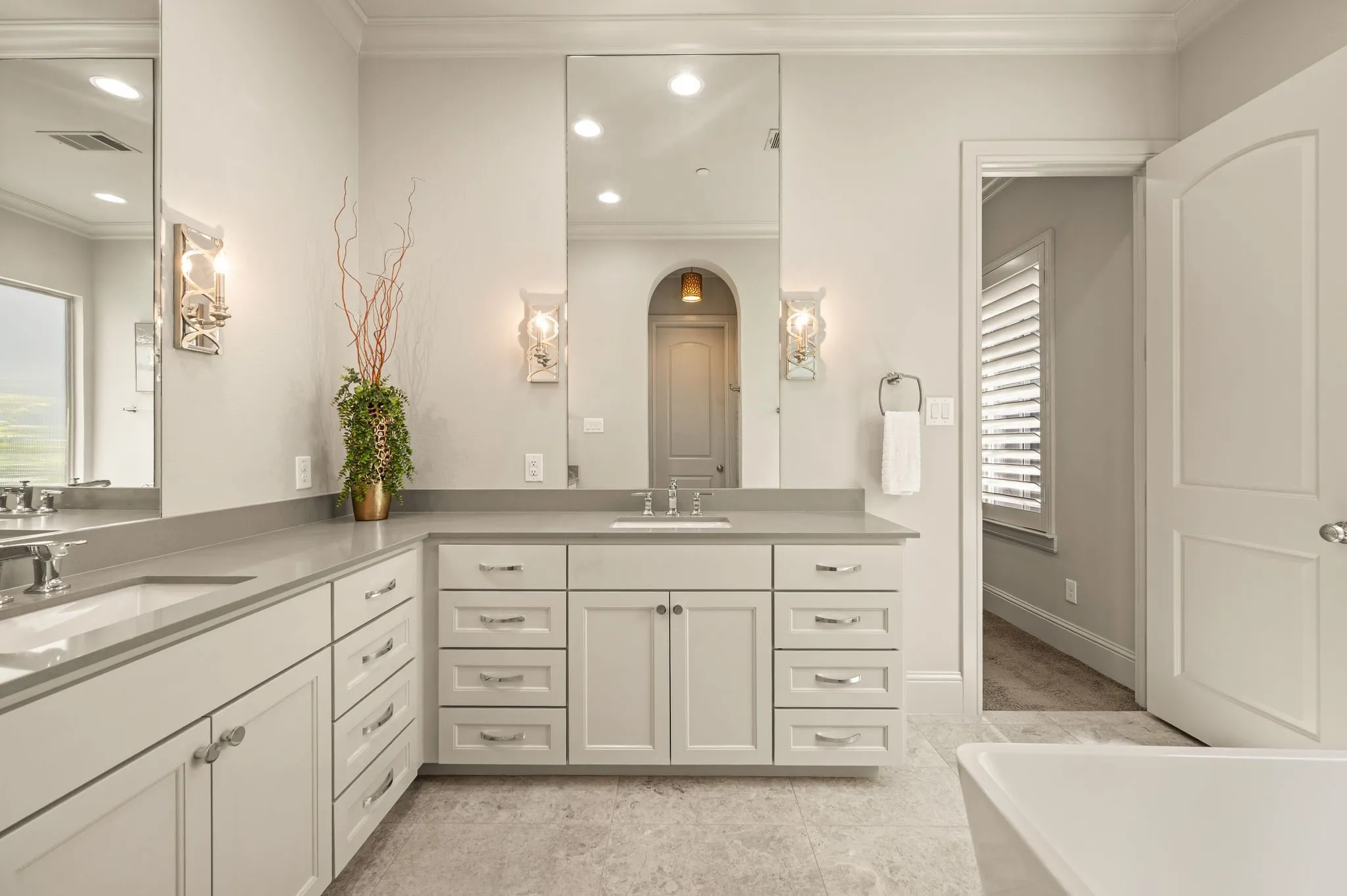 Dual vanity with undermount sinks, gray countertops, and extensive white cabinetry