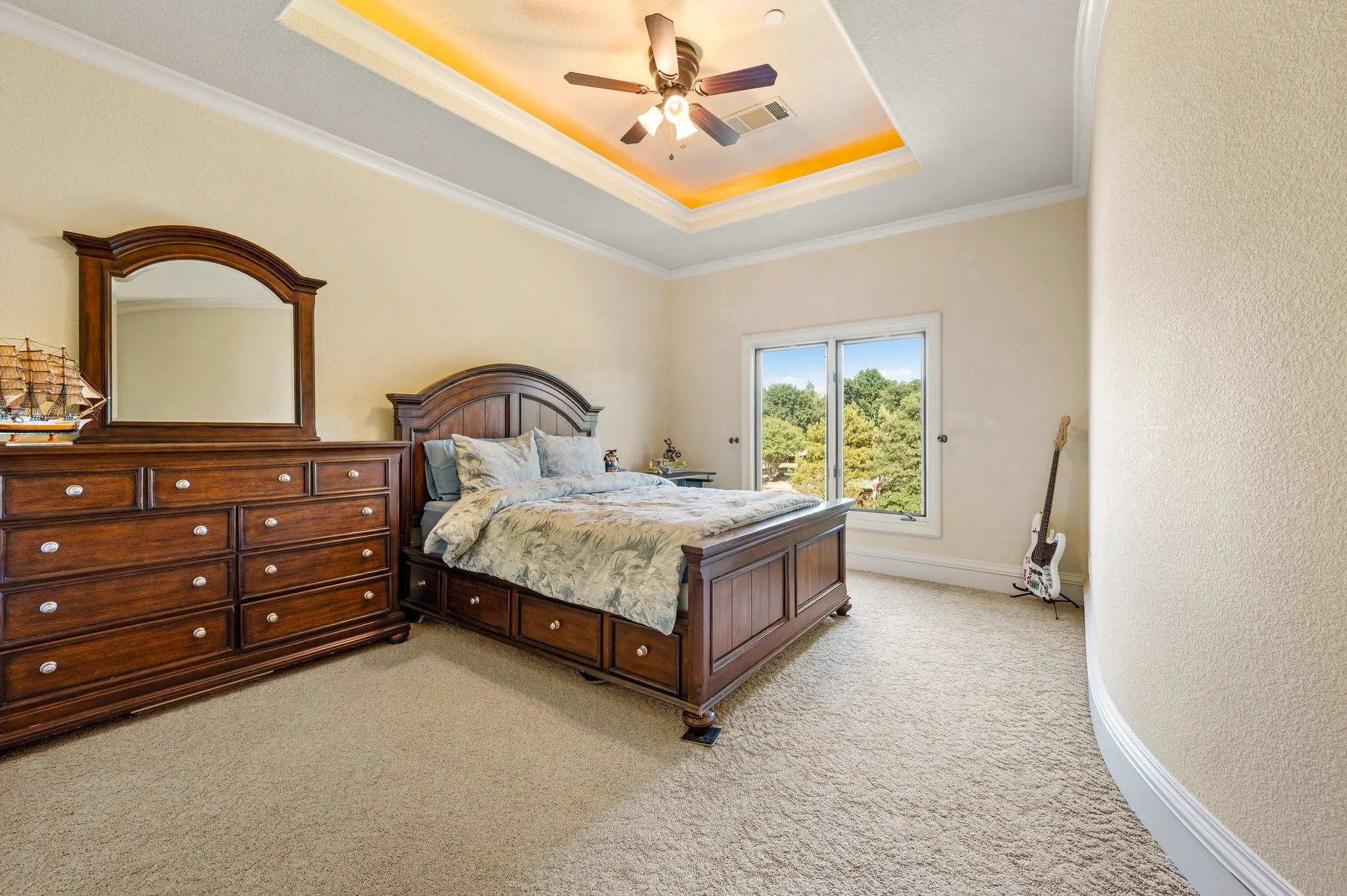 Recessed tray ceiling with integrated lighting, ceiling fan, and crown molding