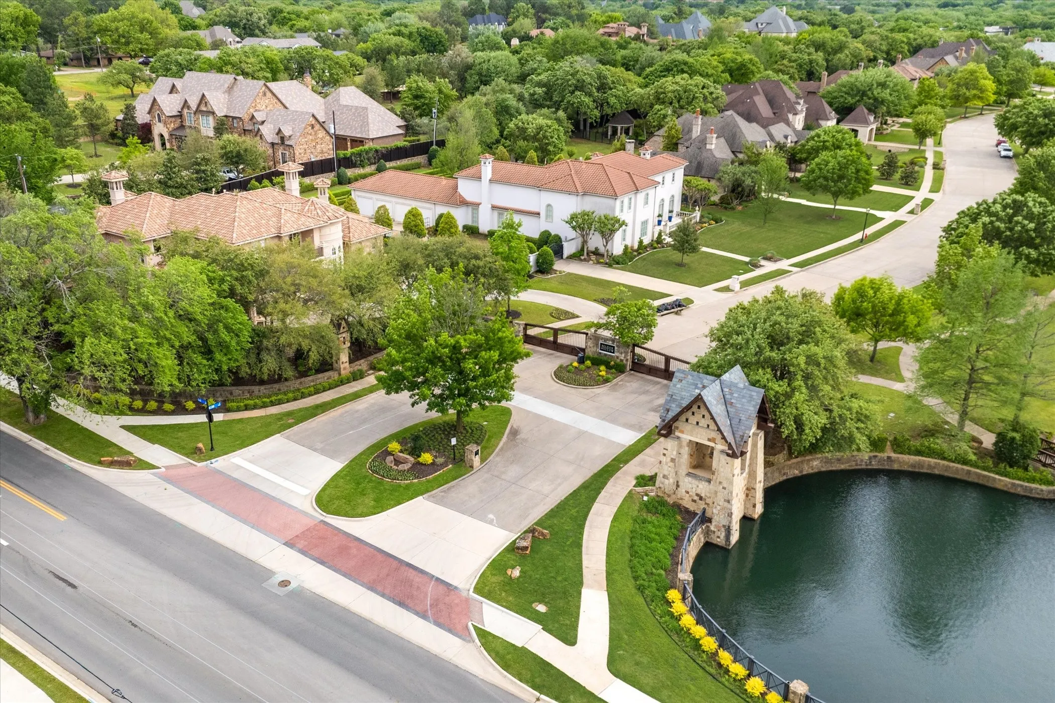 Gated Entry to the Prestigious Beldon Hollow with manicured grounds, mature landscaping, and a private waterfront setting