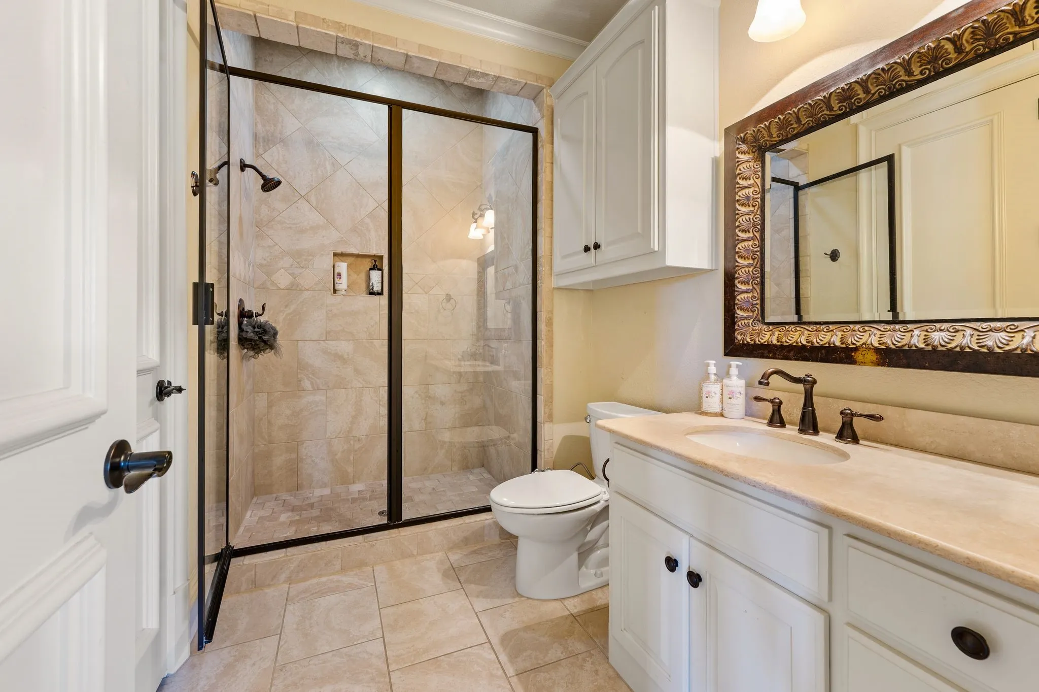 Walk-in shower with clear glass enclosure and tile surround