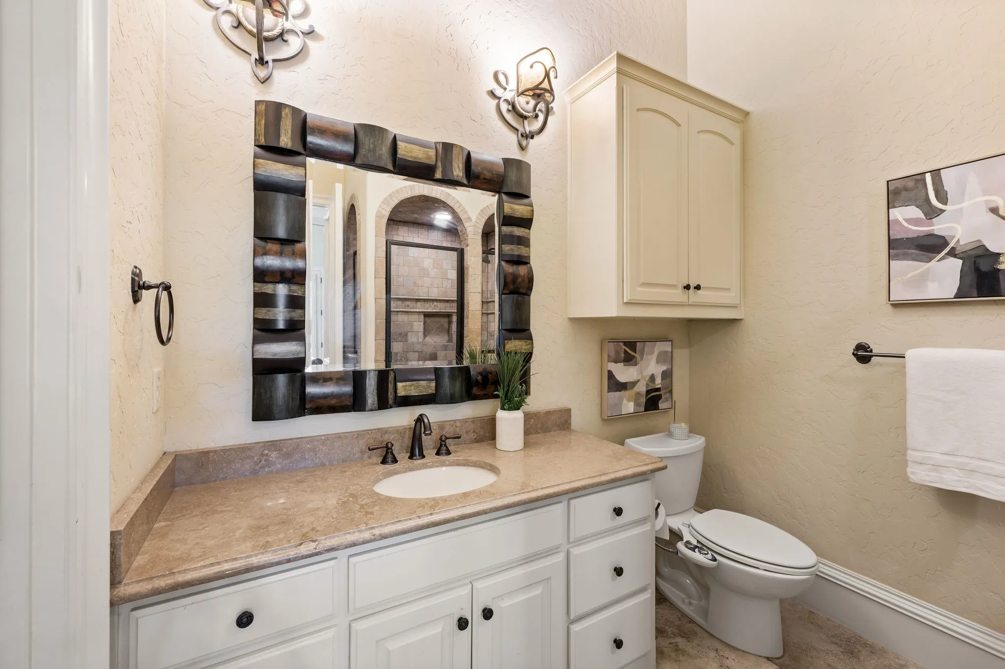 Light-toned vanity with an integrated sink and bronze-finish faucet