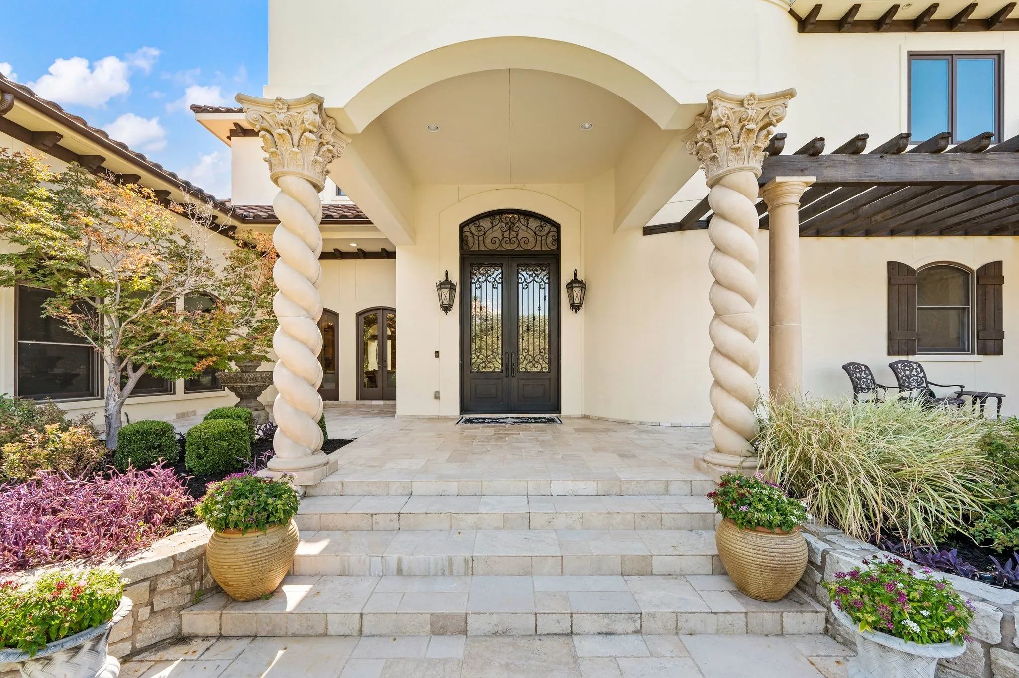 Arched entryway featuring ornate double doors and spiral columns