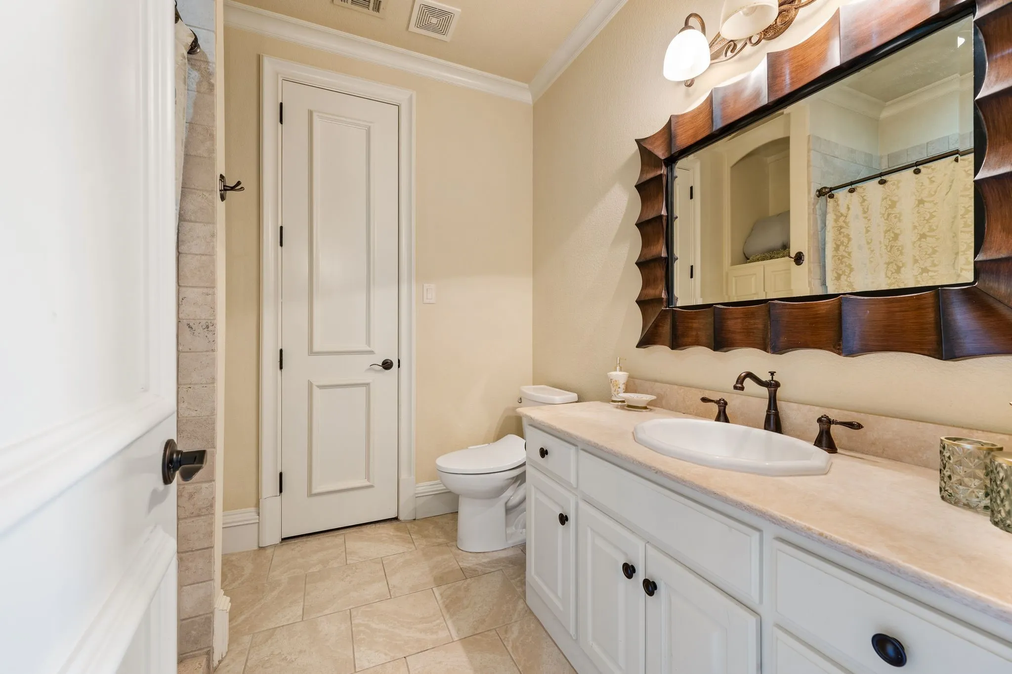White vanity with a neutral-toned countertop and an undermount sink