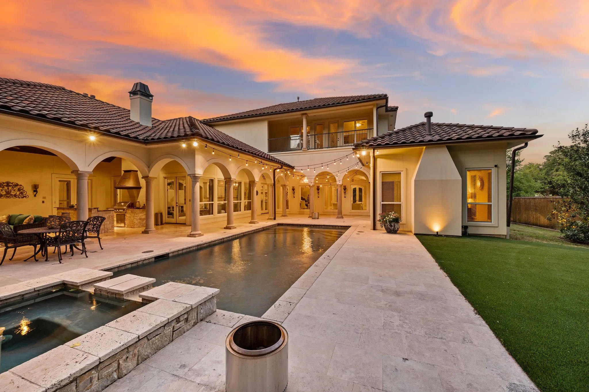 Expansive outdoor living area featuring a swimming pool, integrated spa, and an arched loggia