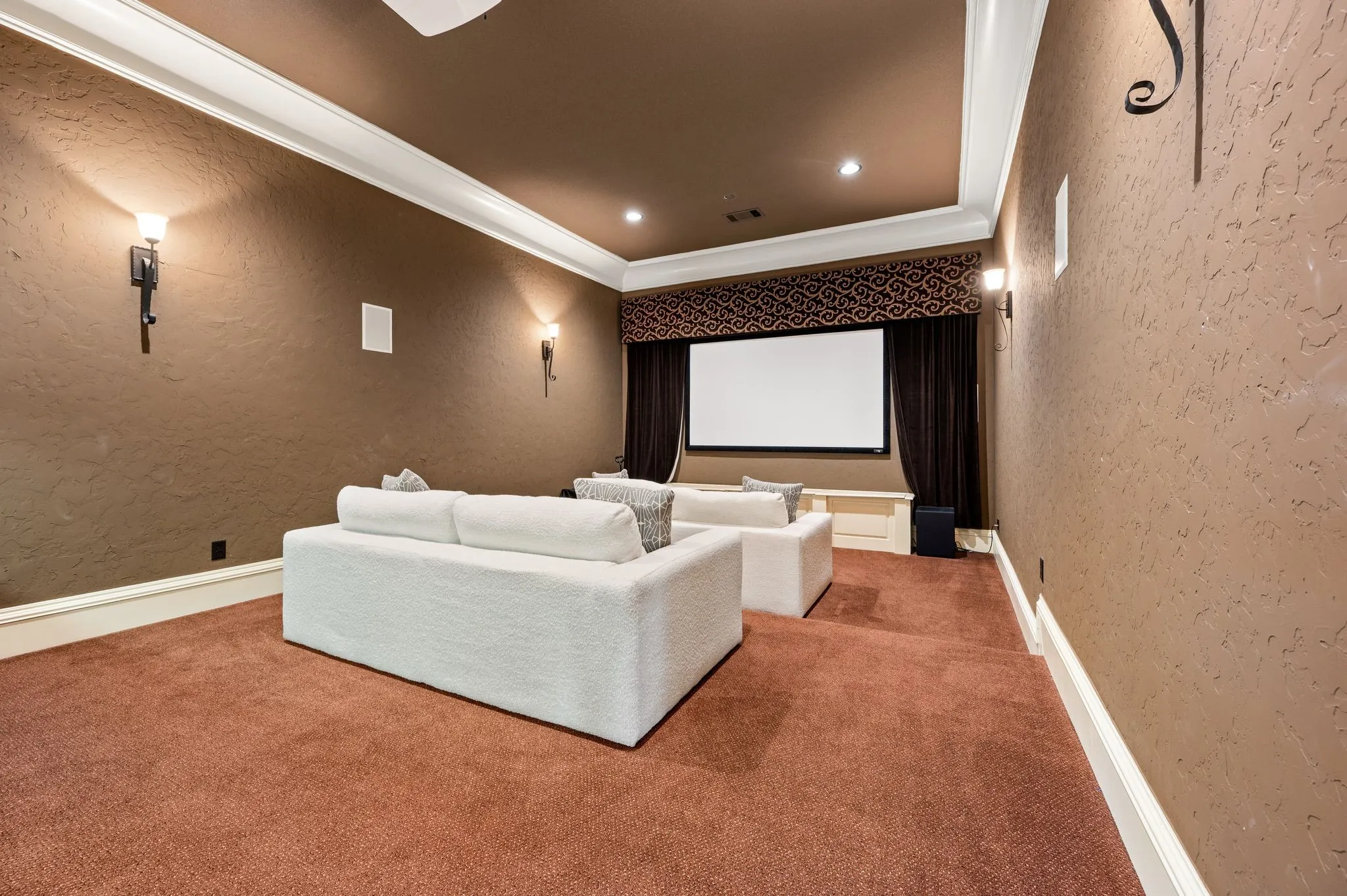 Recessed projection screen with dark fabric curtains, decorative valance, and built-in wall speakers