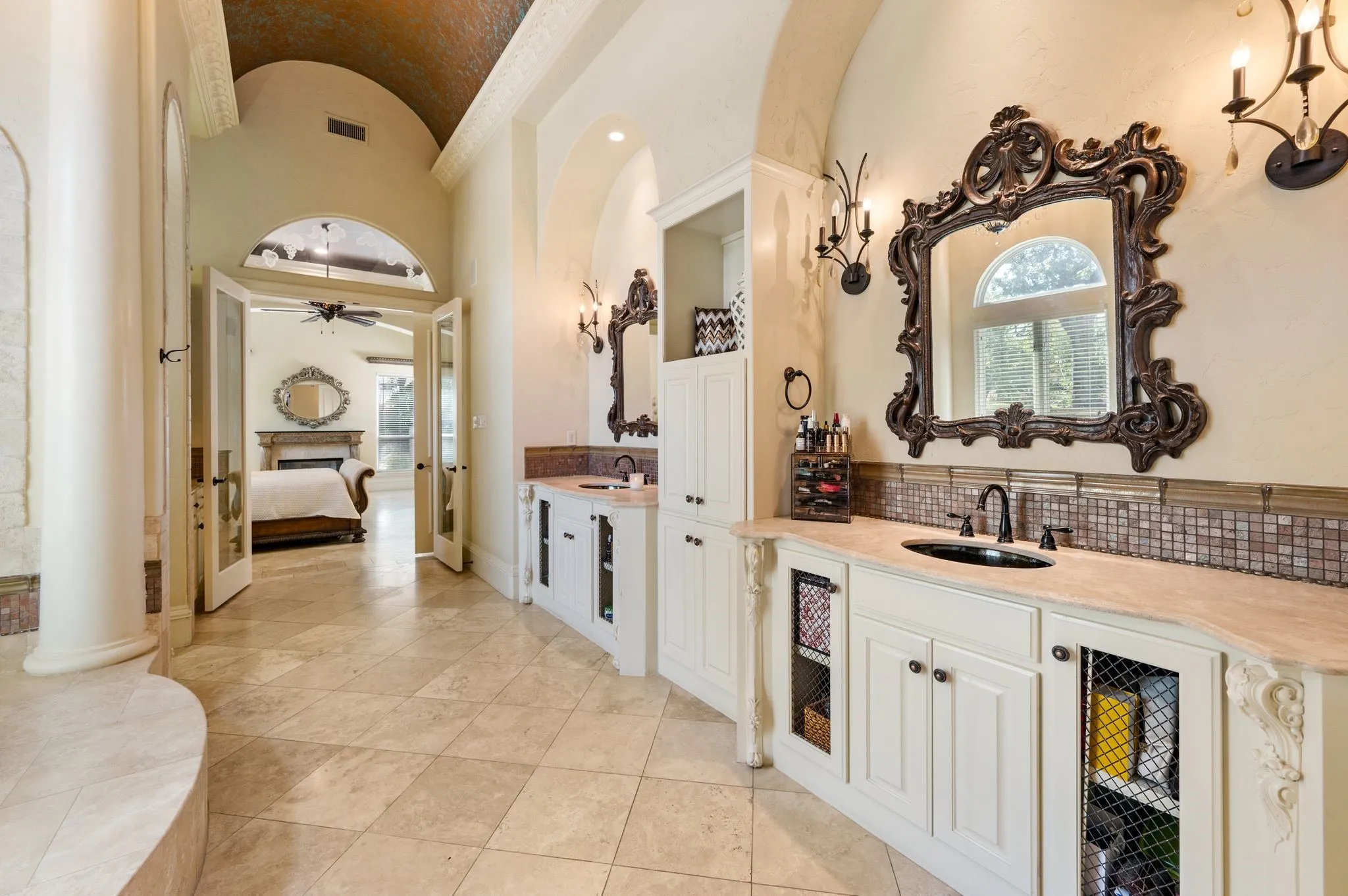 Dual vanity sinks with ornate mirrors and sconces