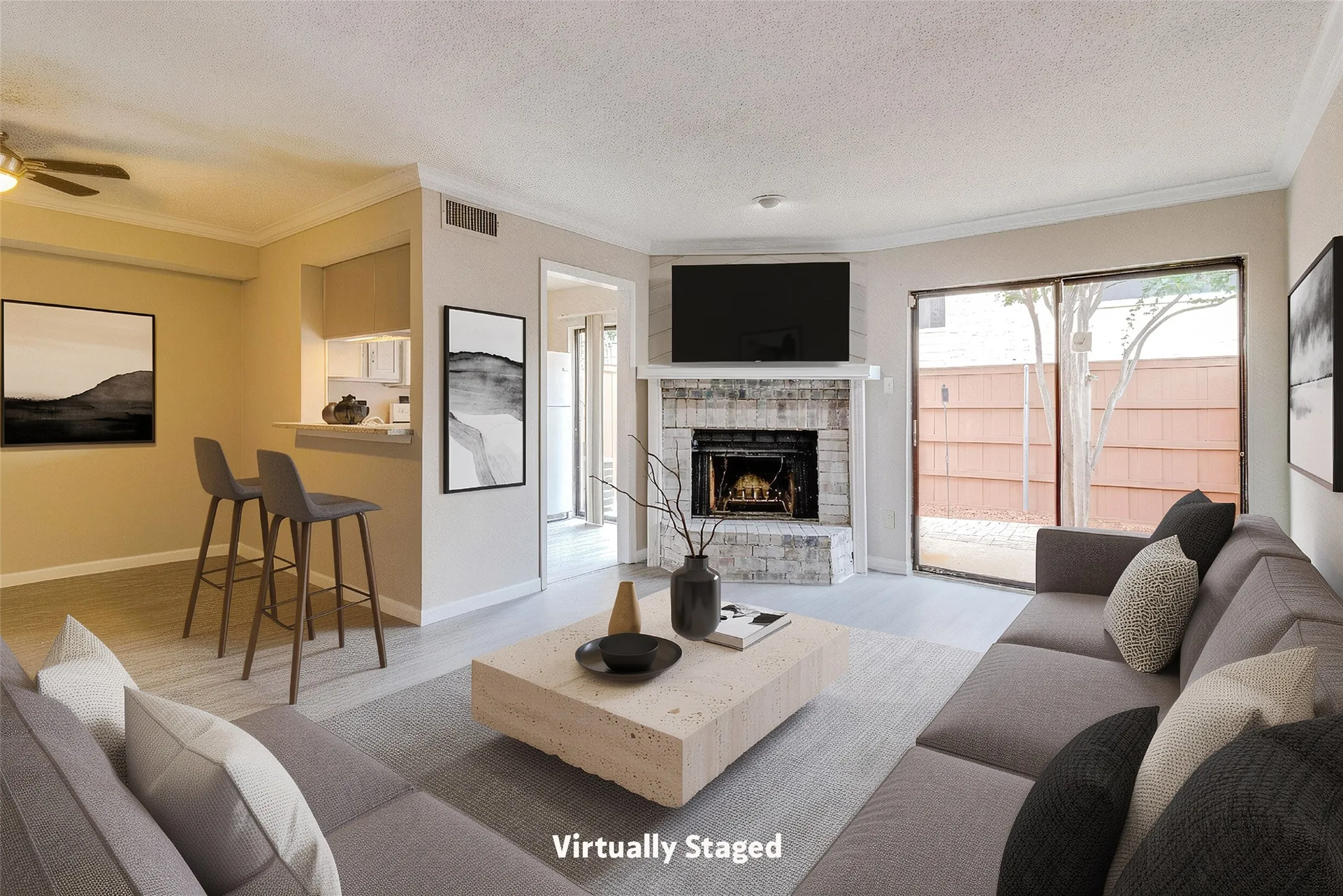 Living area featuring a brick fireplace with a white mantel, light wood-finish flooring, and a sliding glass door