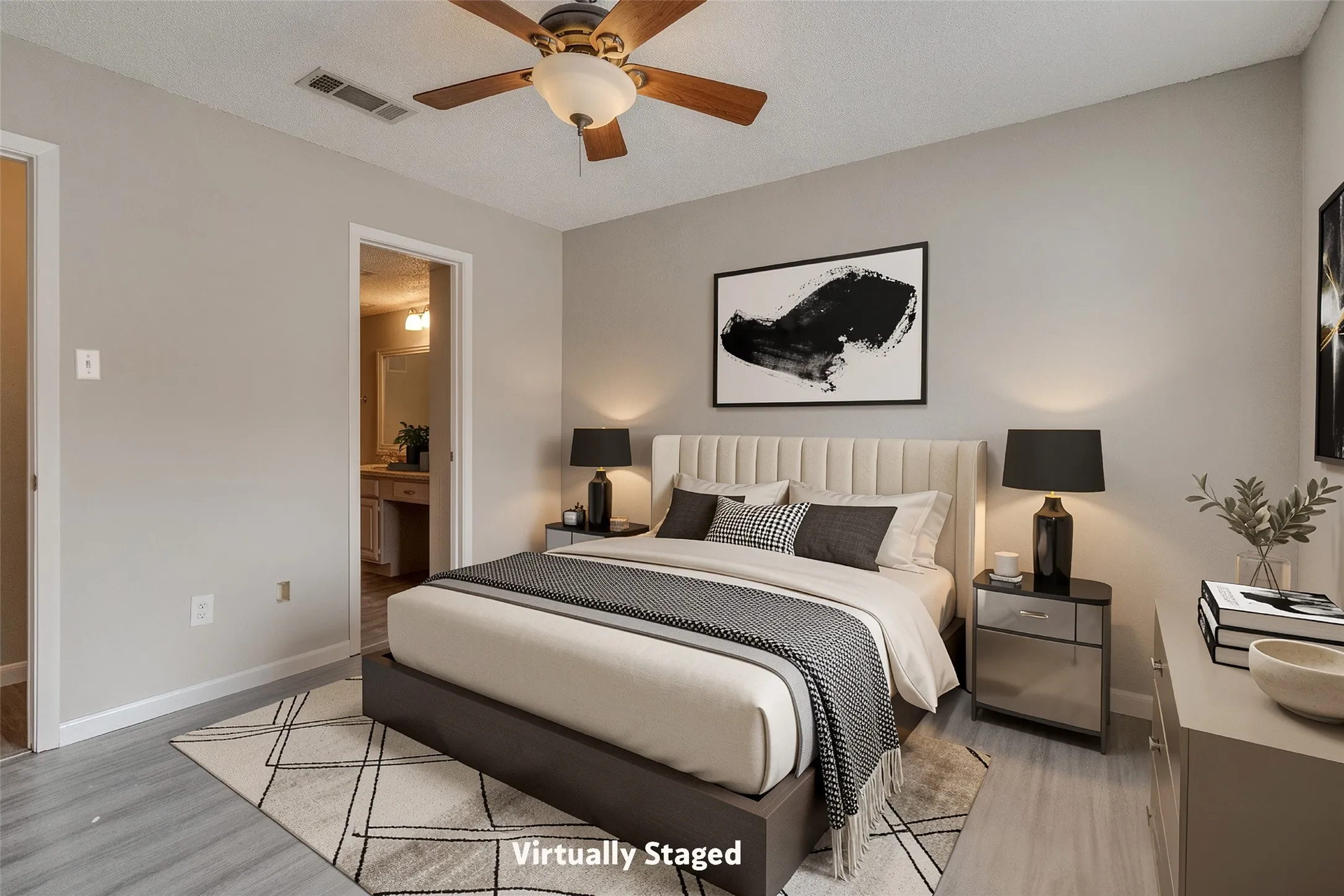 Wood-finish flooring, ceiling fan, neutral wall paint, and an en-suite bathroom