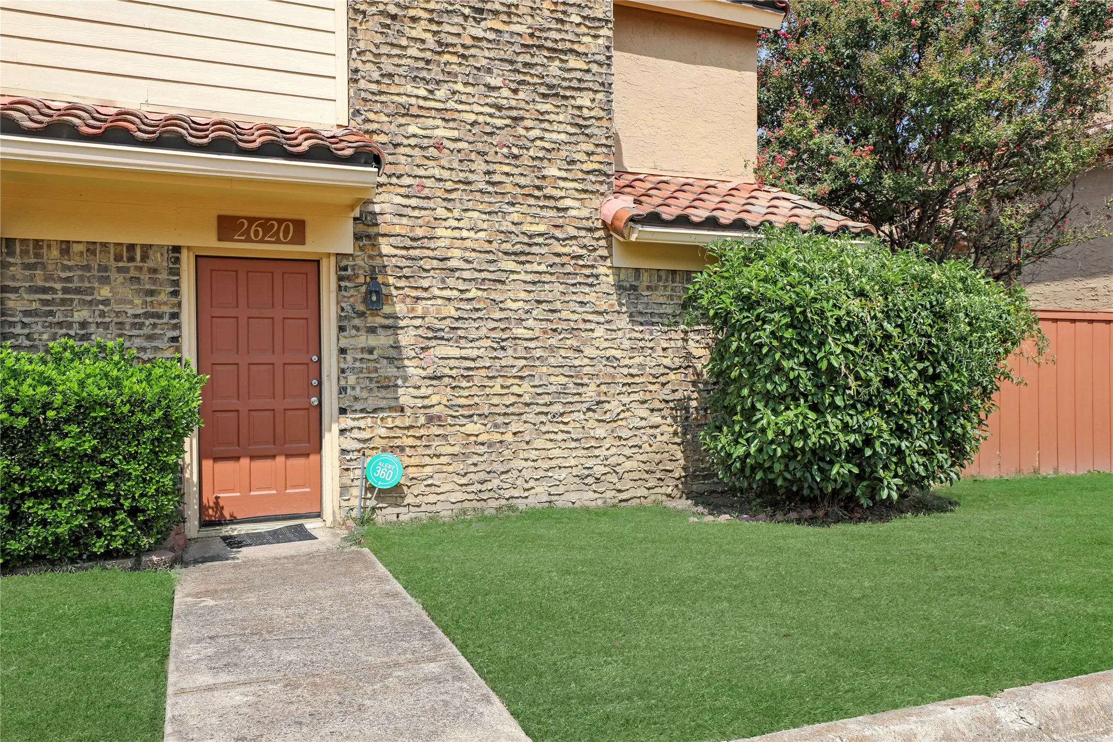 Textured brick facade with a clay tile roof accent