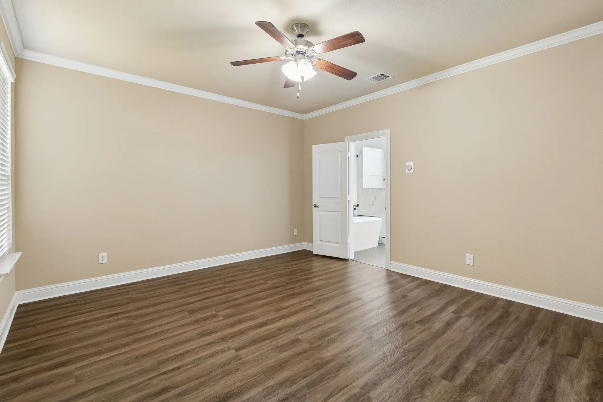 Wood-finish flooring, crown molding, and a ceiling fan with integrated lighting
