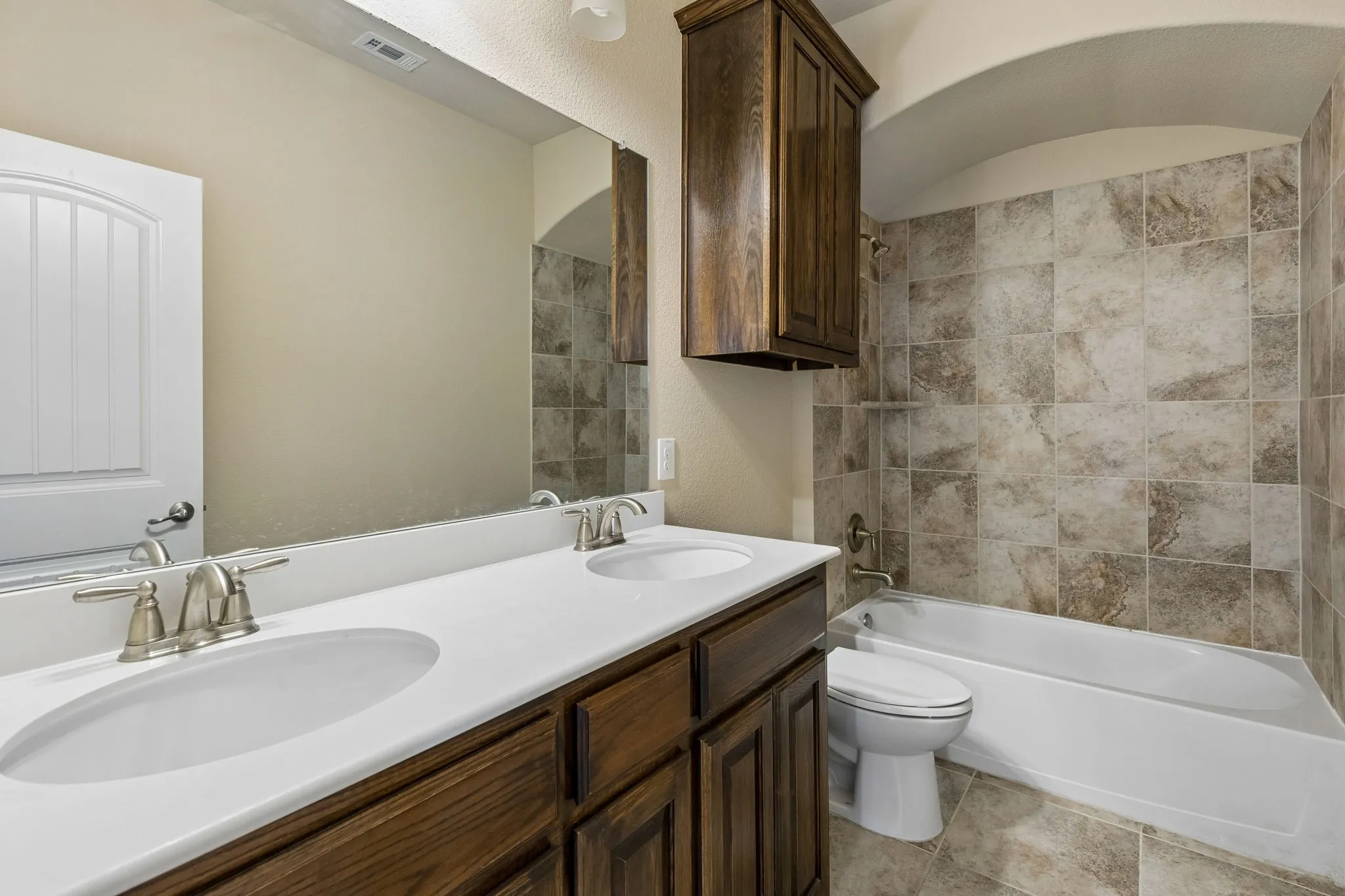 Dual vanity with integrated sinks, brushed nickel faucets, and rich wood-finish cabinetry