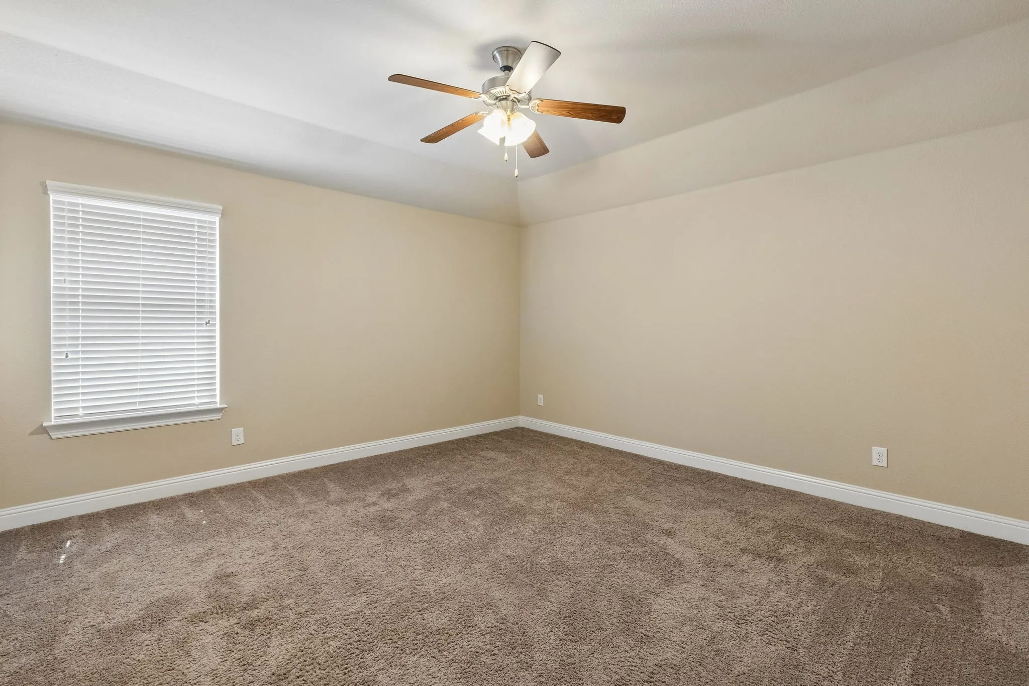 Carpeted flooring, neutral wall tones, window with horizontal blinds, and a ceiling fan with light fixture
