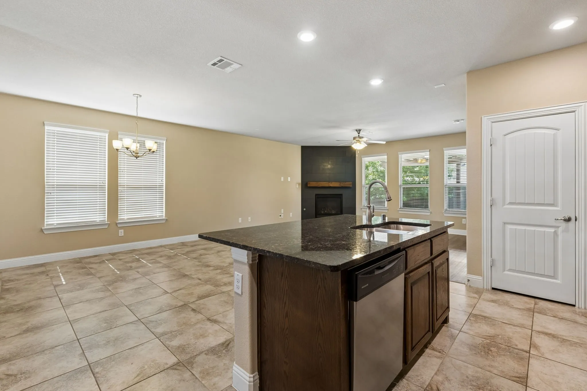 Kitchen island with stone countertop, integrated sink, and stainless steel dishwasher