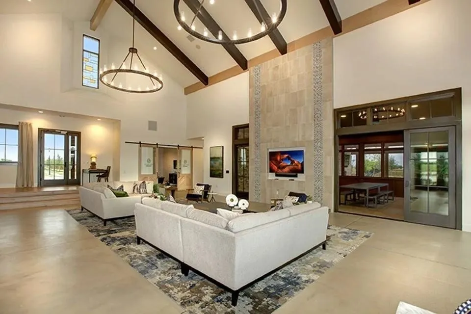 Vaulted ceiling with exposed wood beams, two large circular chandeliers, and stained-glass window