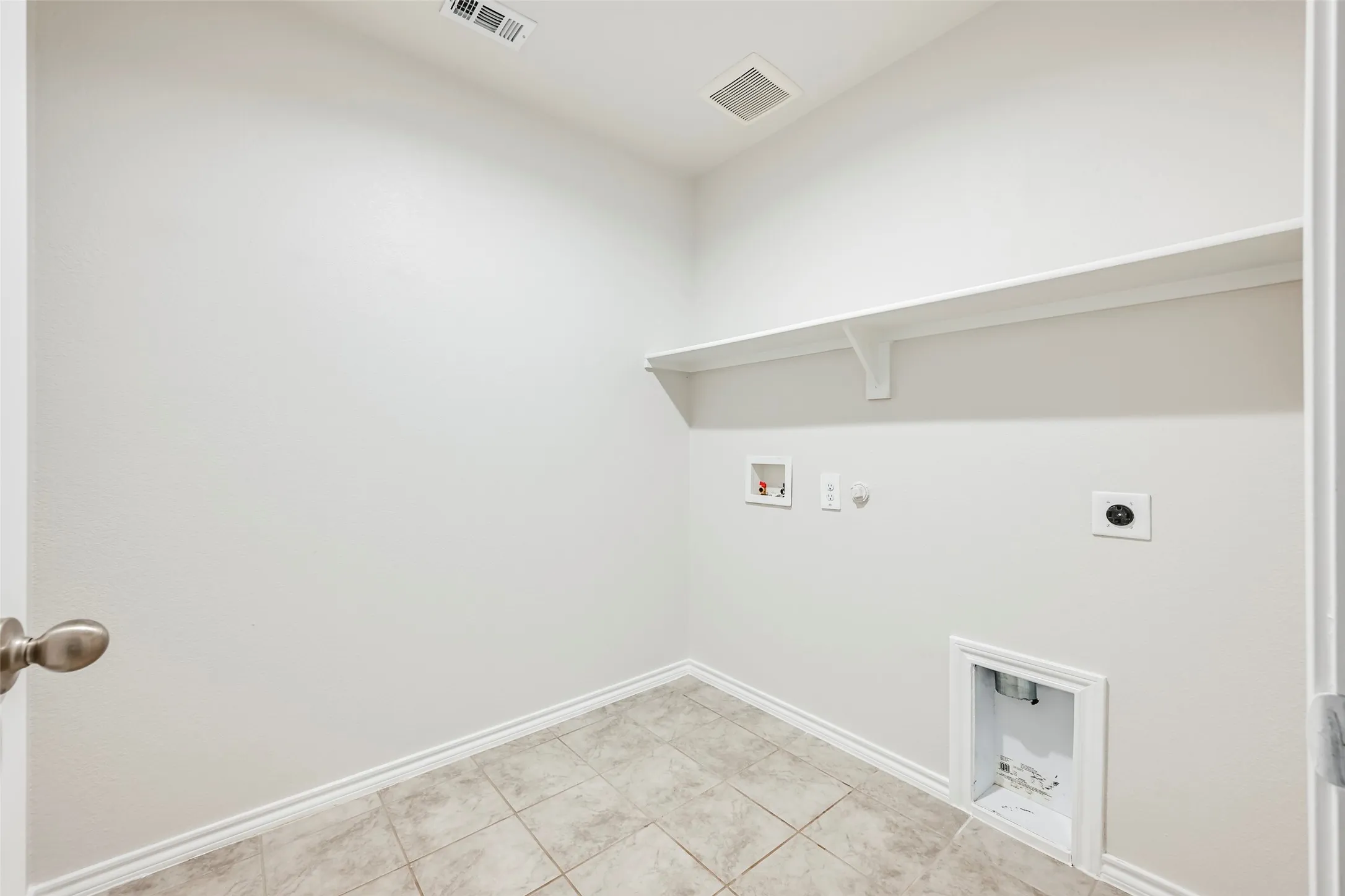 Tile flooring, wall-mounted shelving, and utility hookups