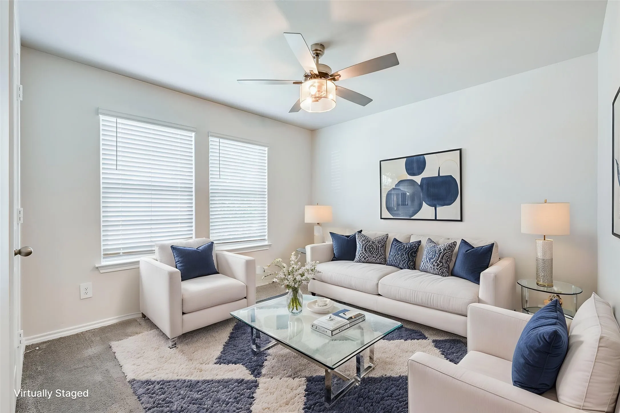 Ceiling fan with light fixture, two windows with blinds, and light-colored walls