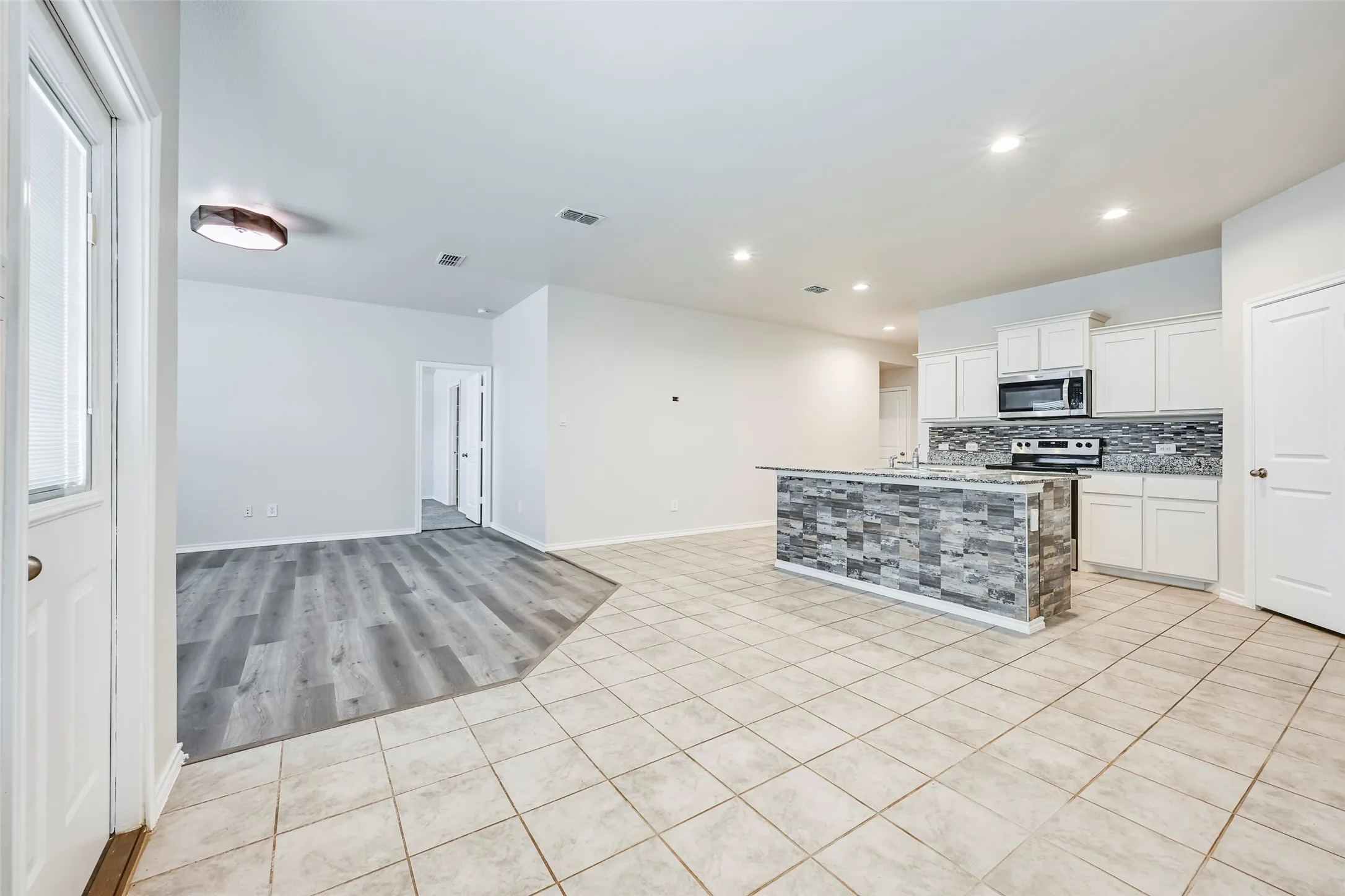 Open-concept living area with tile flooring and recessed lighting