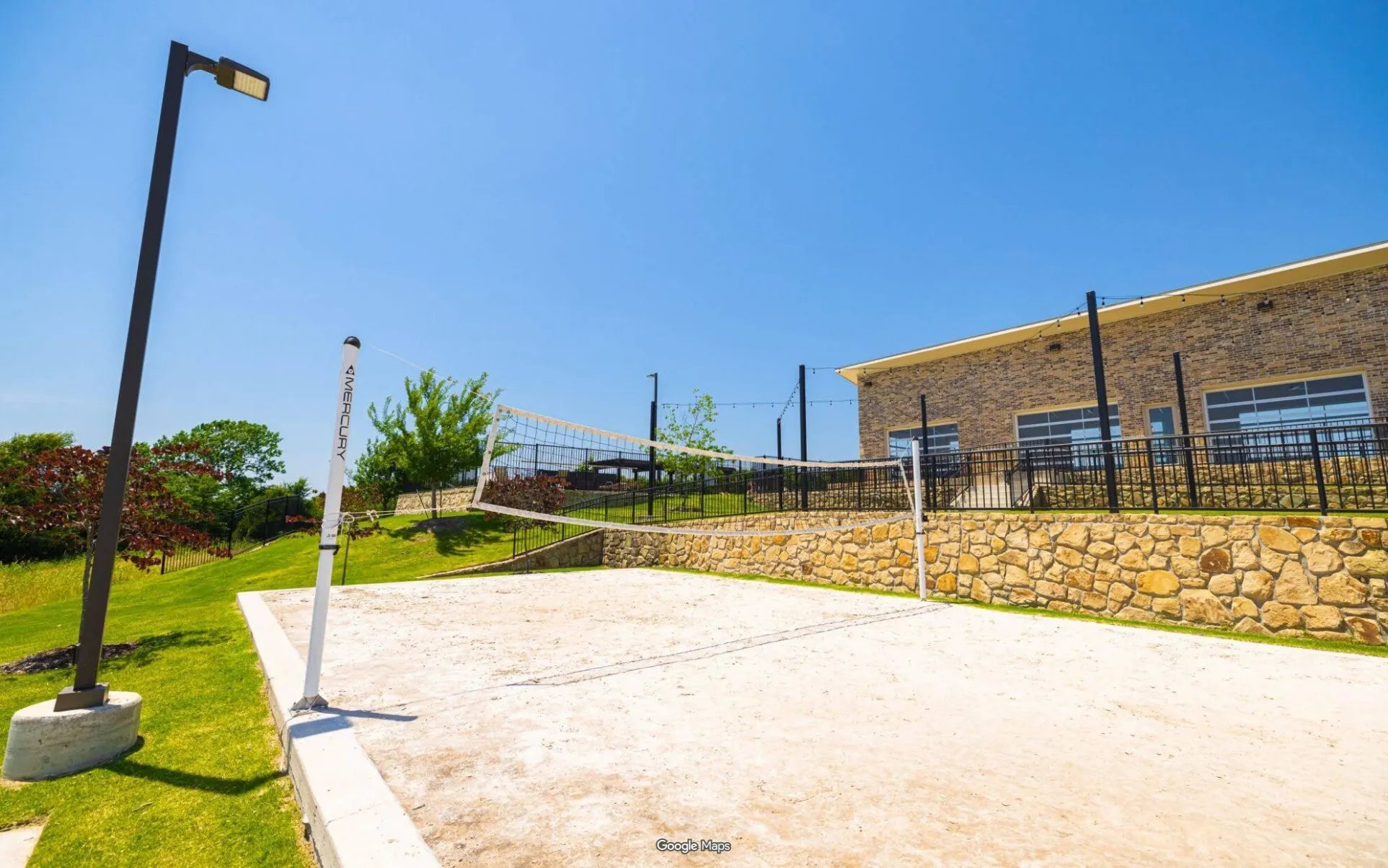 Sand volleyball court featuring a net and perimeter lighting