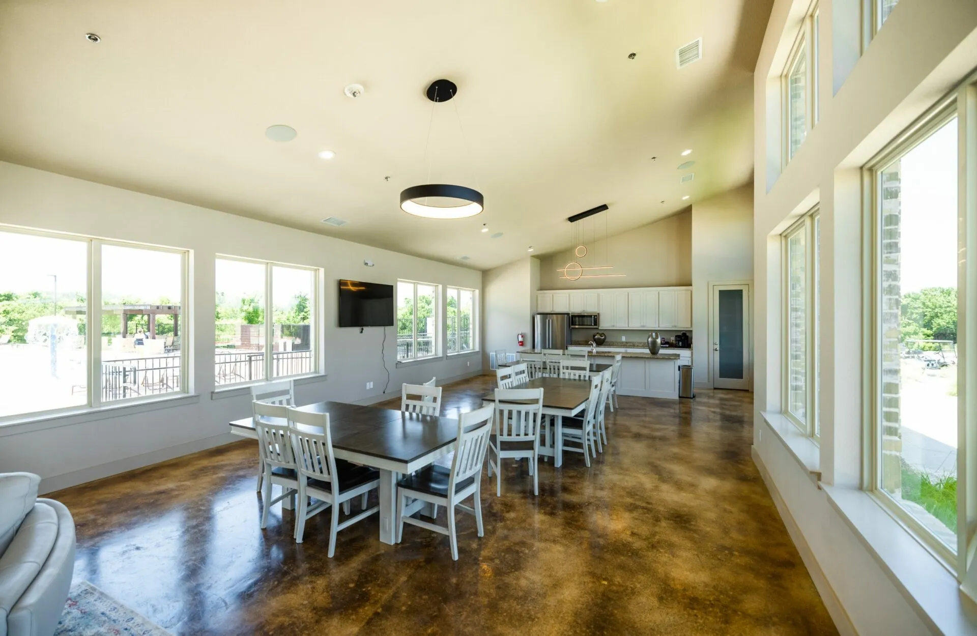 Vaulted ceiling, polished concrete flooring, extensive window banks, recessed lighting, and a contemporary kitchen with stainless steel appliances