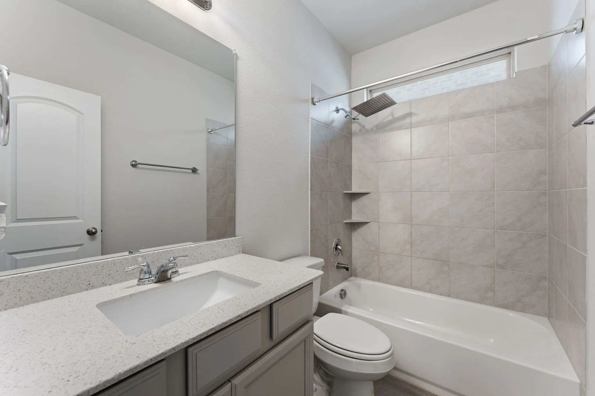 Contemporary bathroom featuring a vanity with a quartz-finish countertop, undermount sink, and chrome fixtures