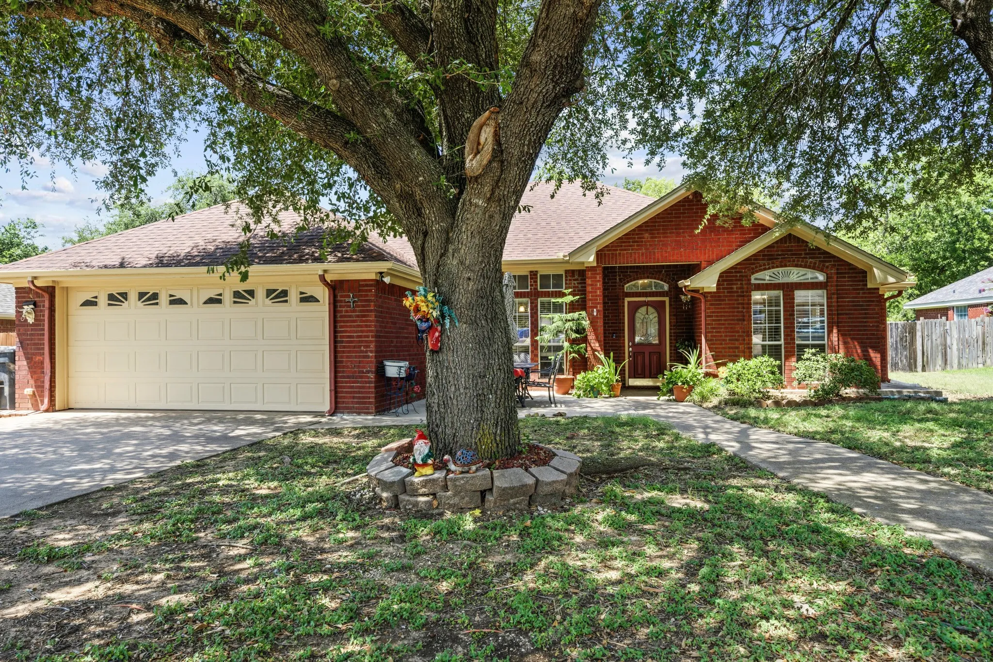 Traditional brick exterior with a prominent front-facing garage, arched window accents, and a covered entryway