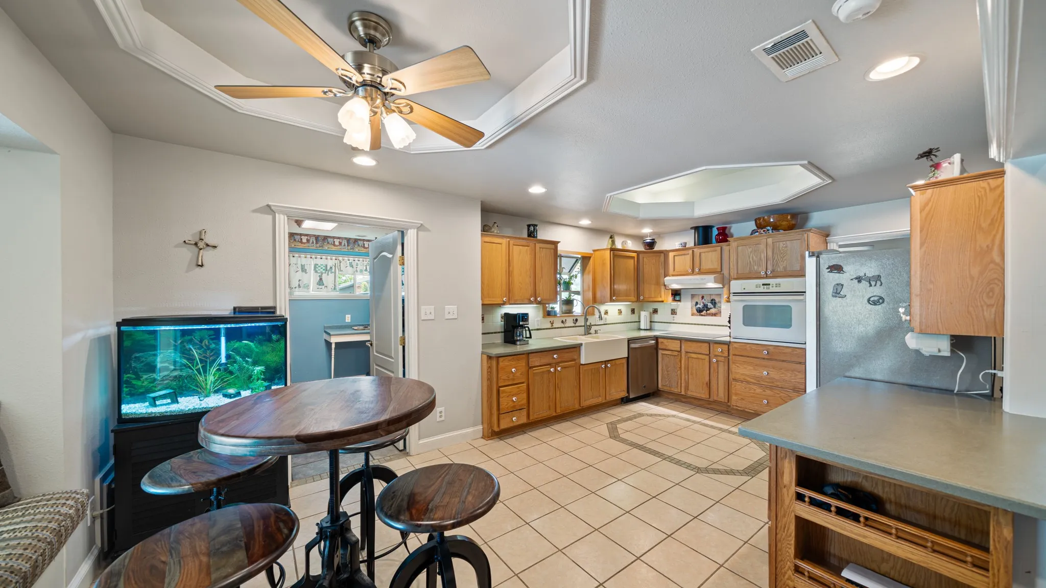 Kitchen featuring oak cabinetry, tile flooring, recessed lighting, and a ceiling fan