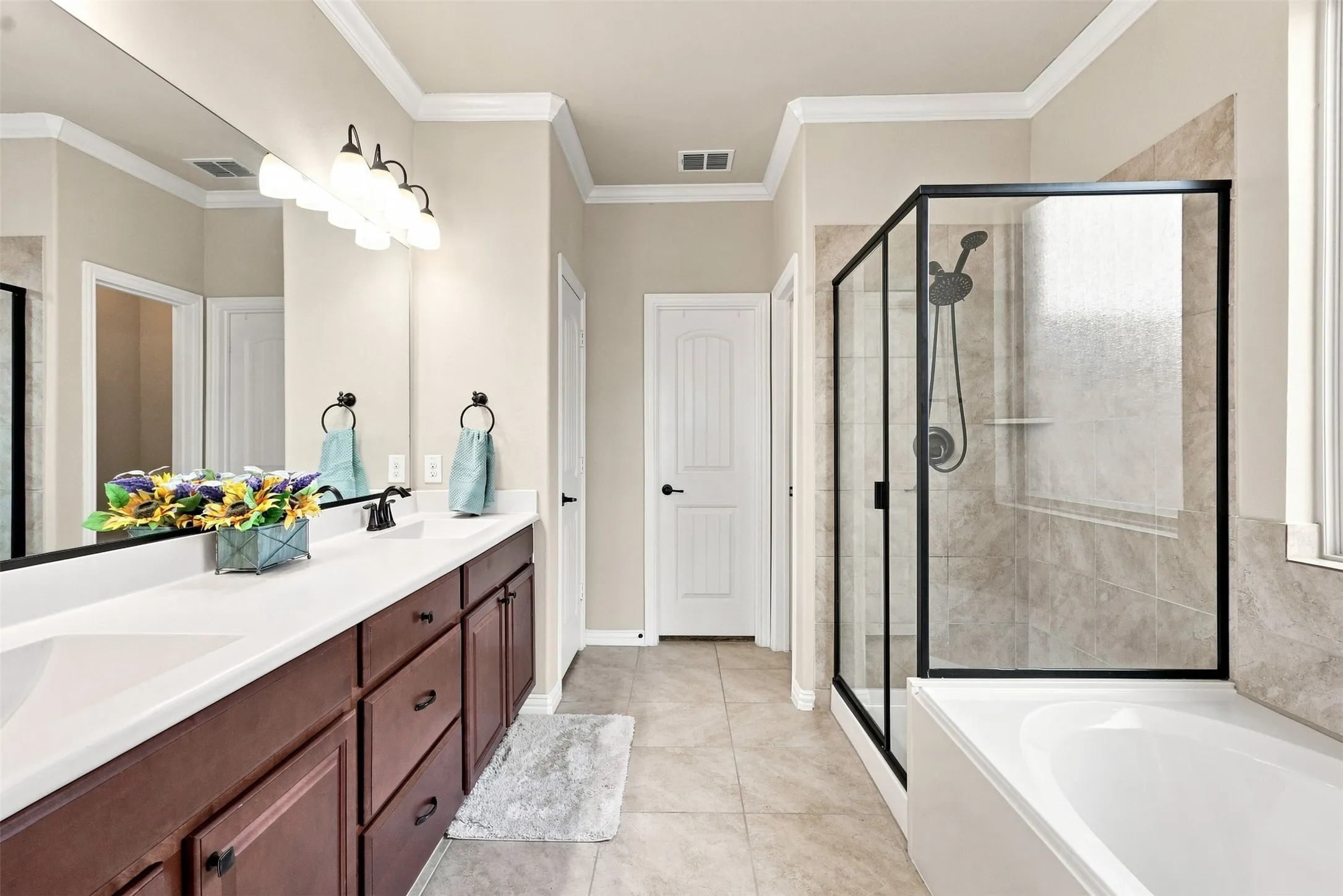 Features Decorative Lighting, Ceramic Tile, Double Sinks, Separate Garden Tub with Window and Shower, Water Closet, Linen Closet, and Generous Walk-in Closet.