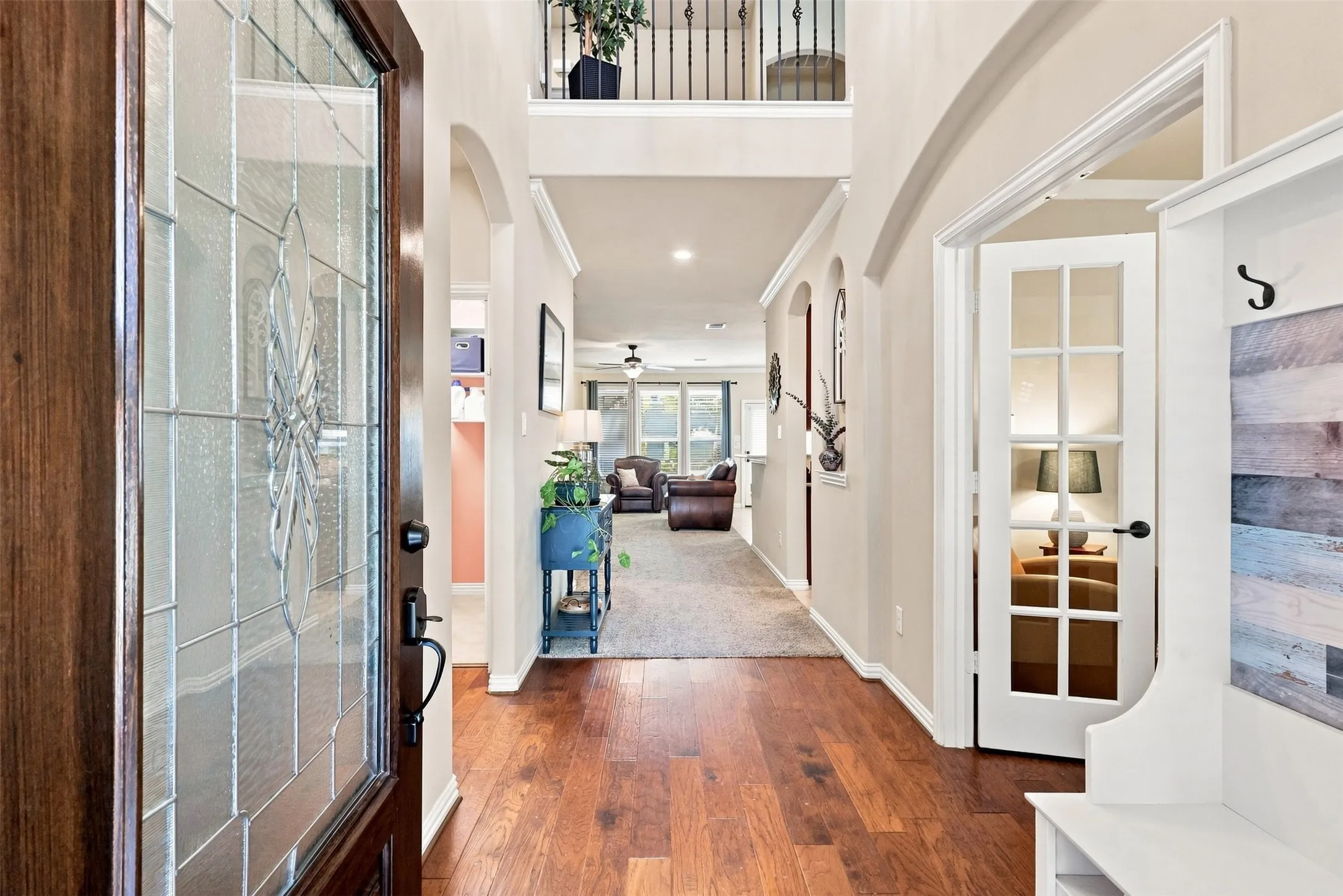Decorative Glass Door and Engineered Hardwood Floors. Office is to the right of Entry and Utility, Half Bath, and Garage are to the left.