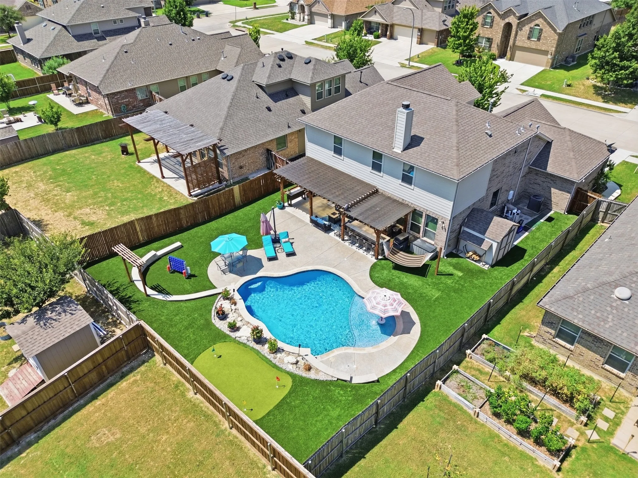 View of Resort-style backyard which includes Hammock and Shed with Electricity.