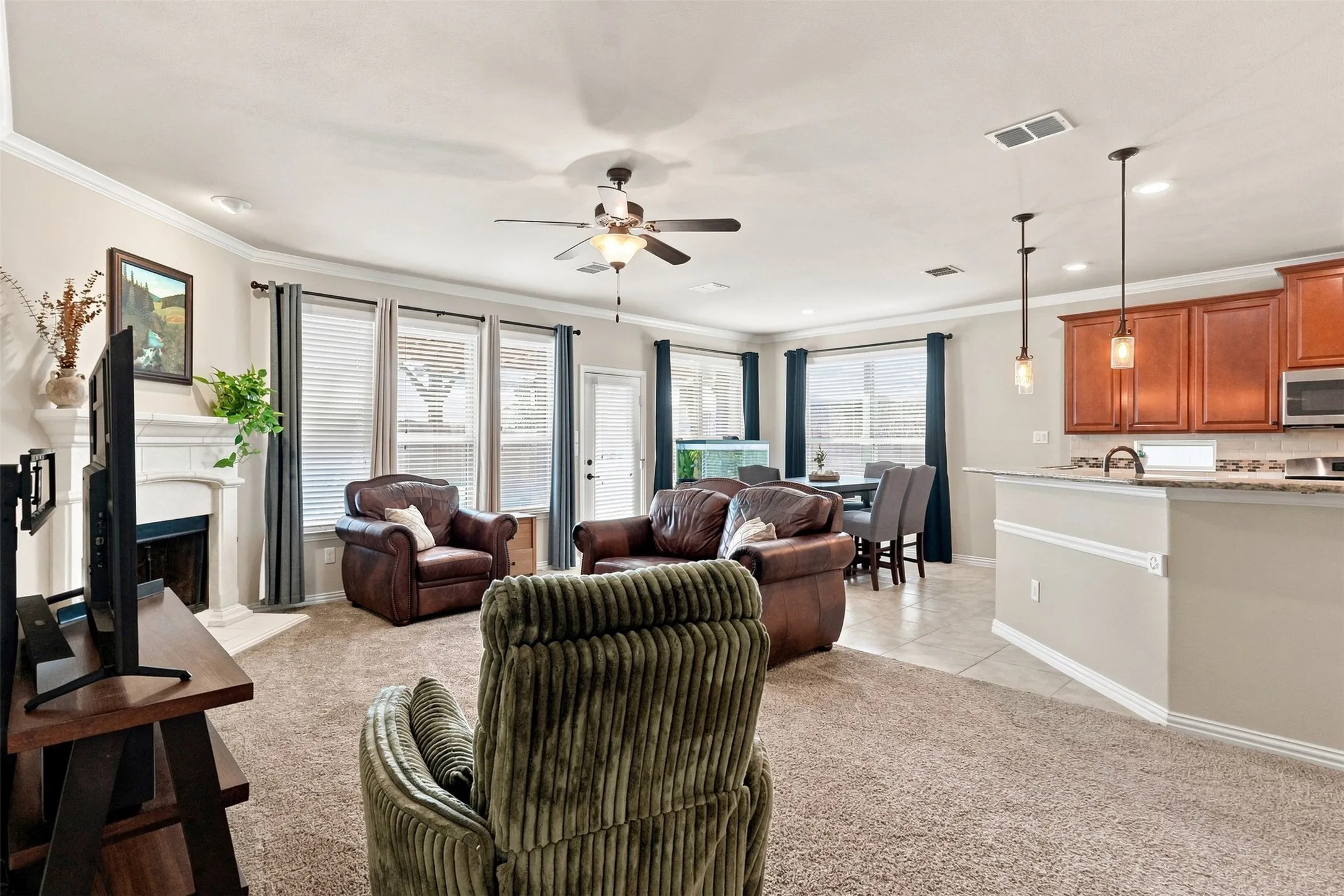 Open Floor Plan Living Room features a Fireplace, Crown Molding and views of the Resort-style backyard.