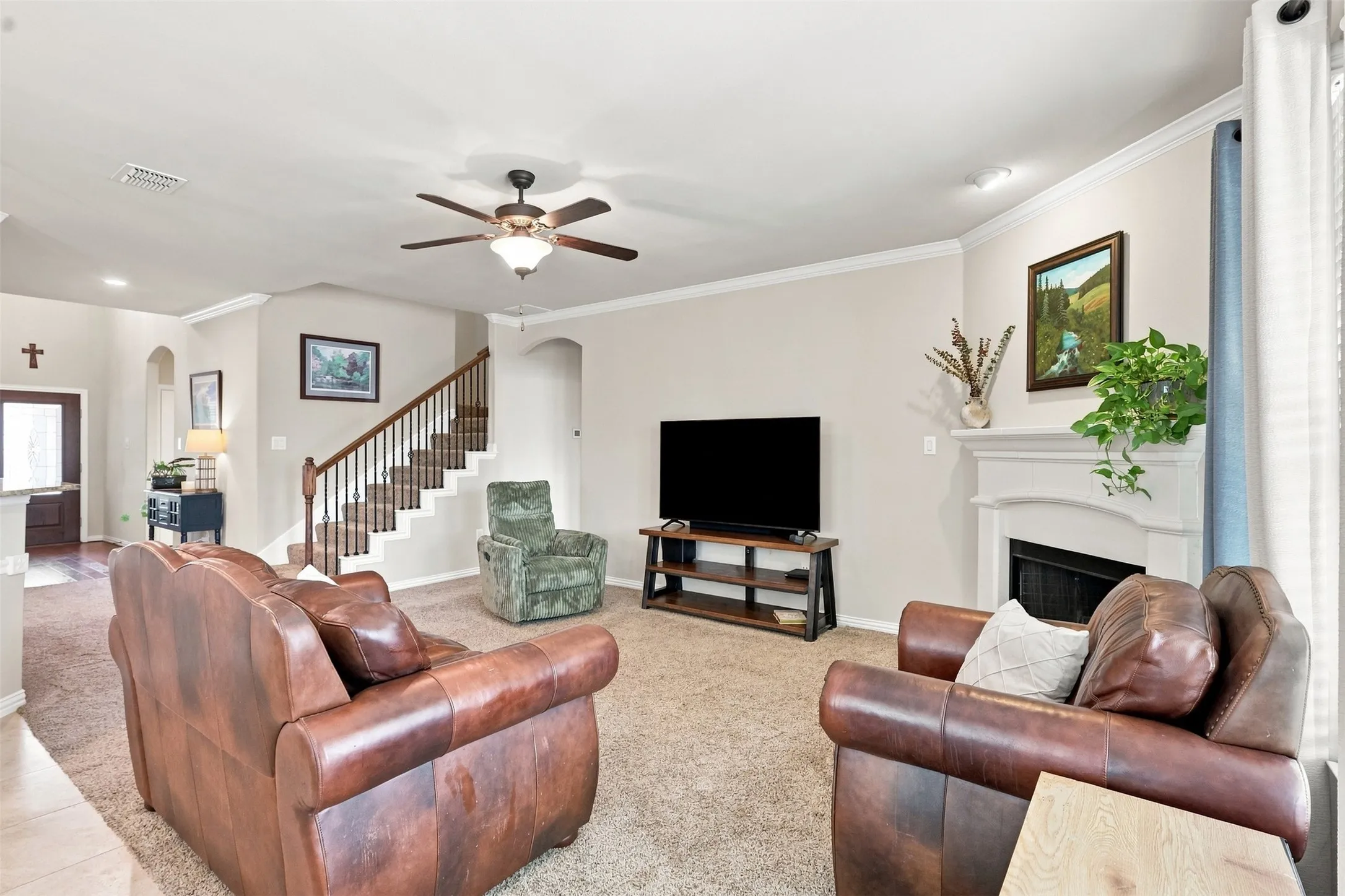 Open Floor Plan Living. Living Room Features a Fireplace and Crown Molding.
