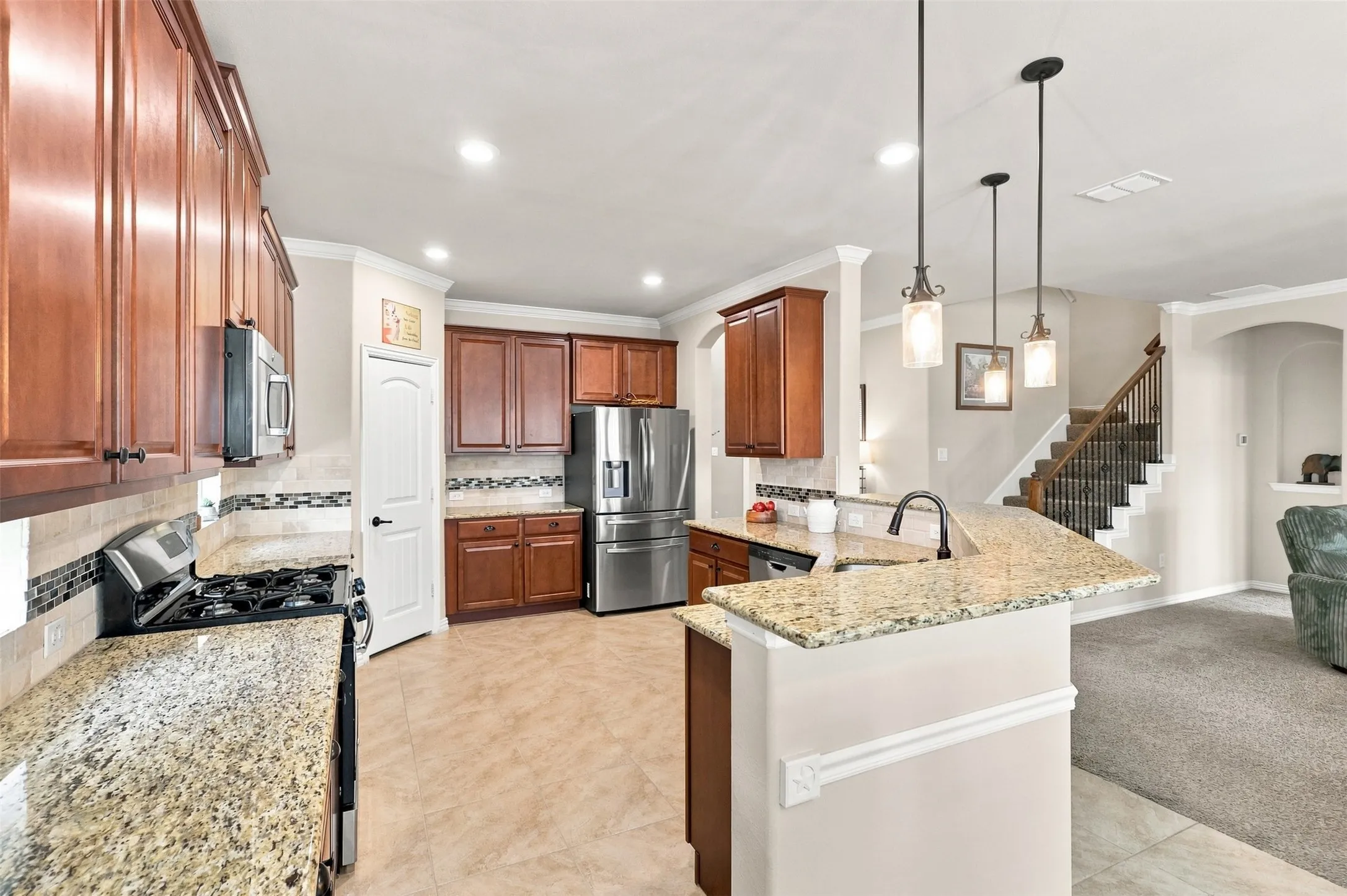 Open Gourmet kitchen featuring Gas Range and Oven, Walk-in Pantry, Decorative Windows, Ceramic Tile, and Breakfast Bar.