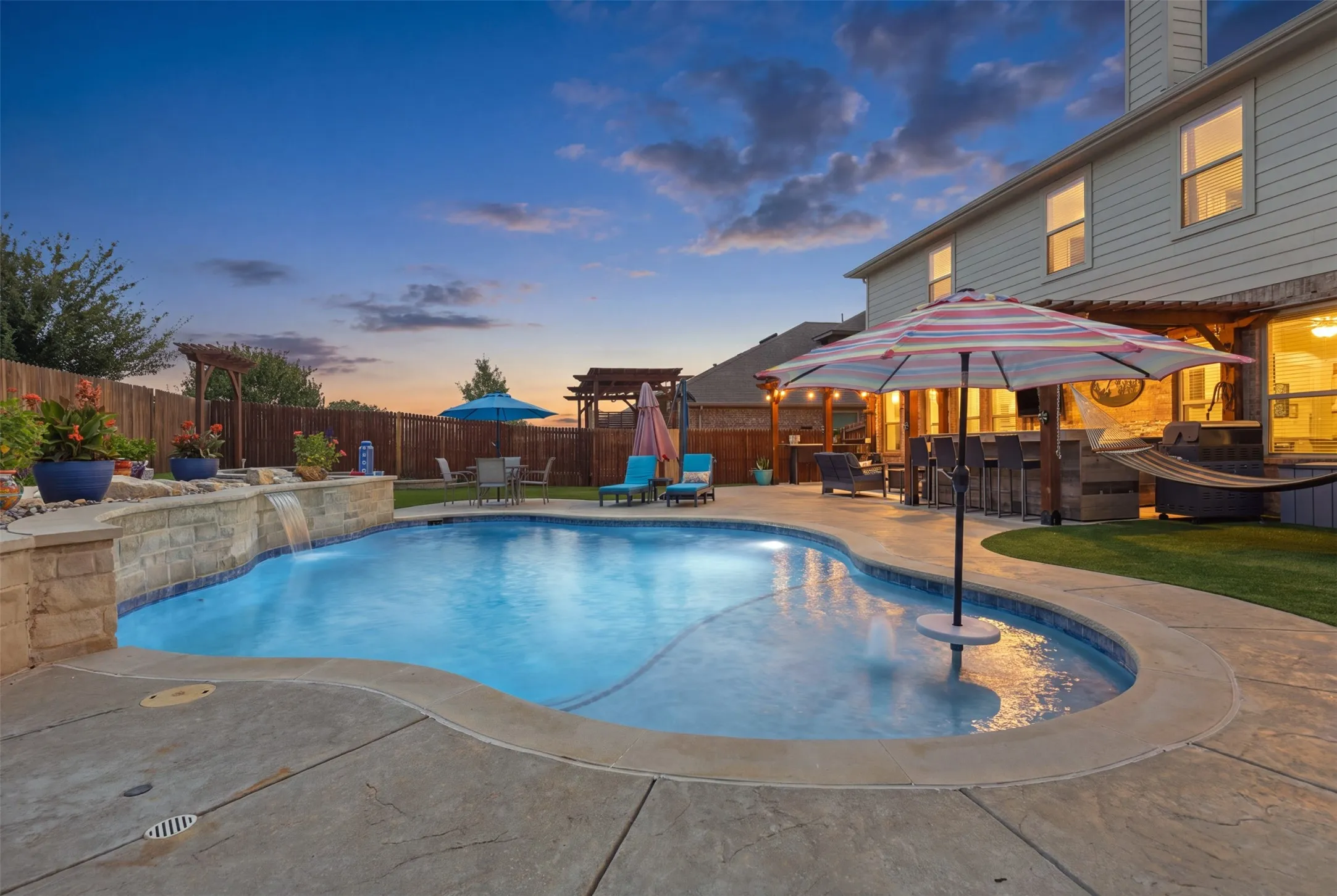 Resort style gunite pool with waterfall, tanning bed, and in ground filtration.
