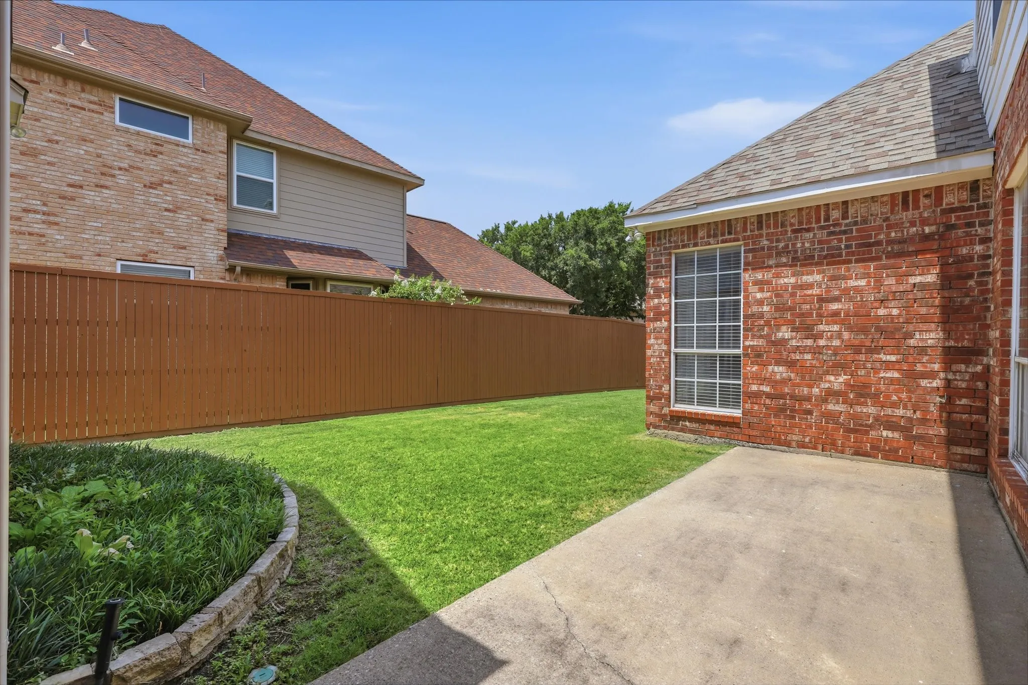 Another backyard view highlighting the outdoor living space and lawn.