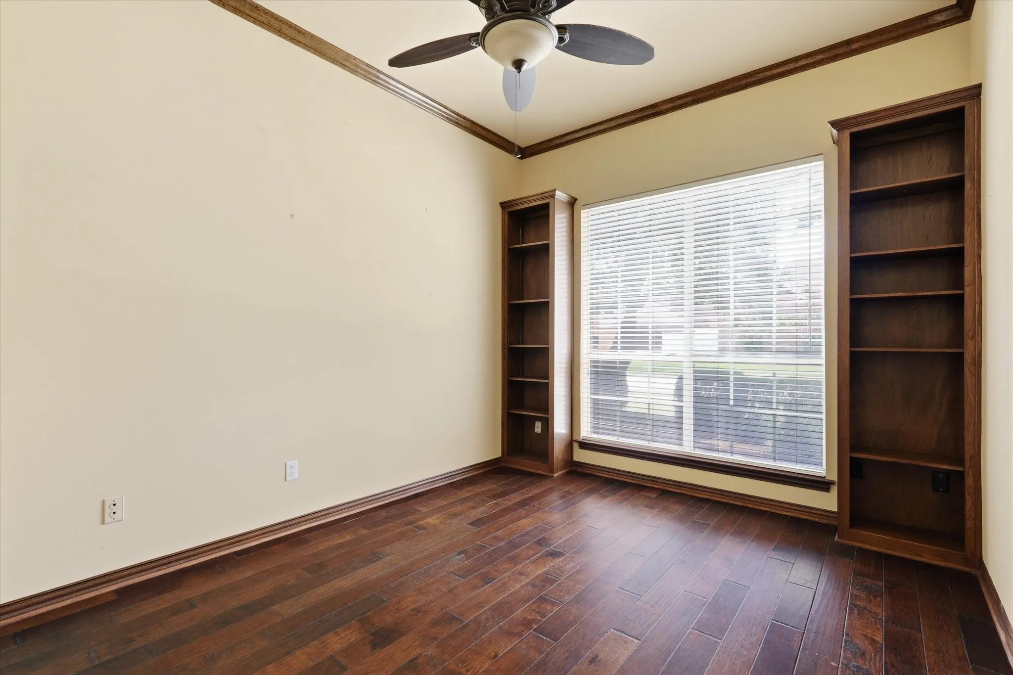 Secondary bedroom located on the first floor off the kitchen with hardwood flooring and large windows providing excellent natural light.