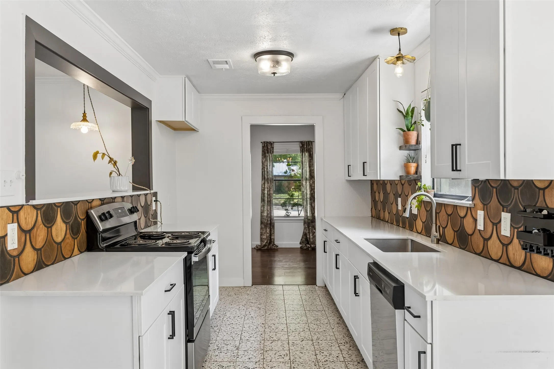 Galley kitchen with quartz counters, Terrazzo tile floors connects formal dining