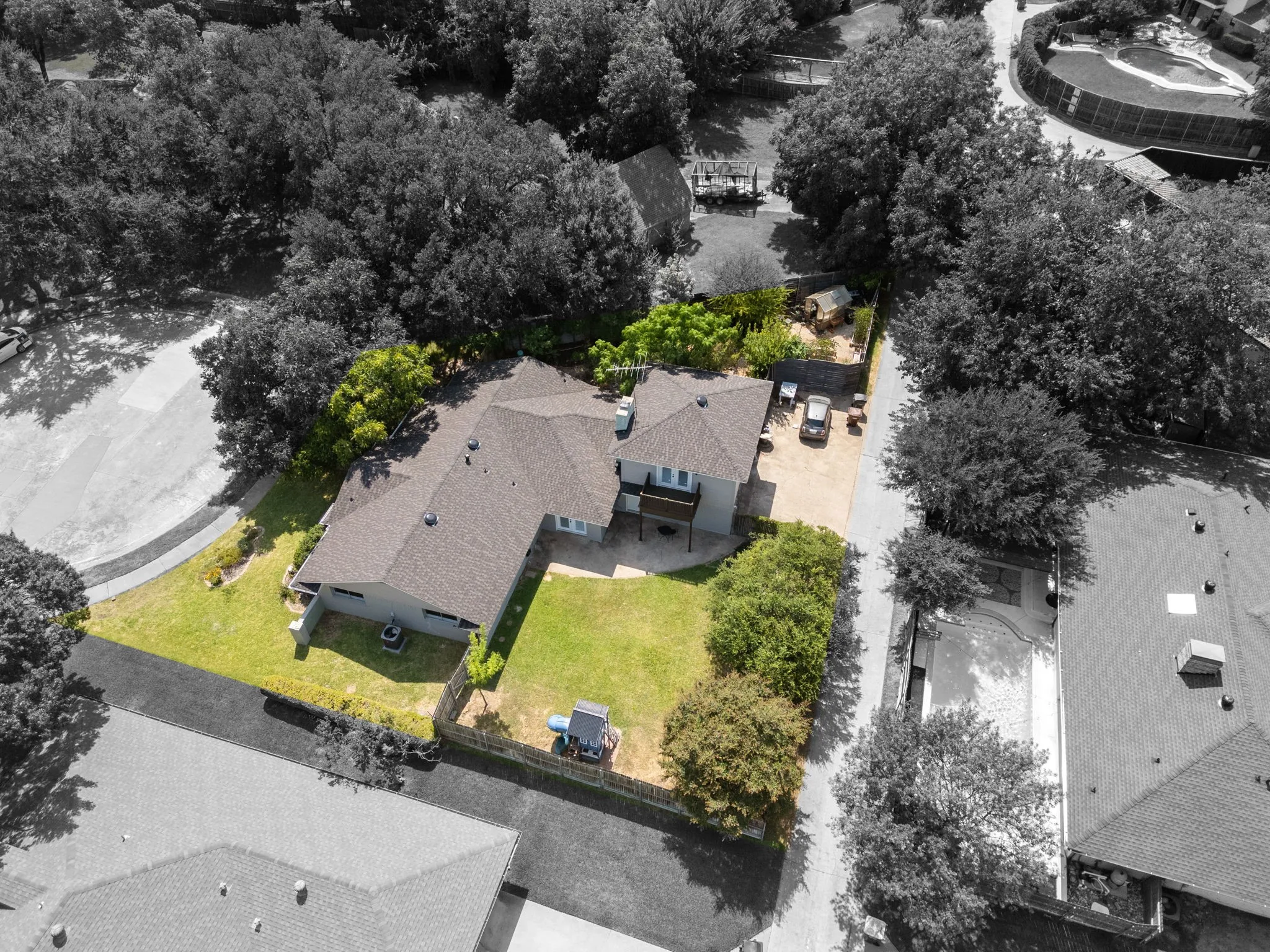 Expansive property featuring a multi-level home, paved driveway, and mature landscaping
