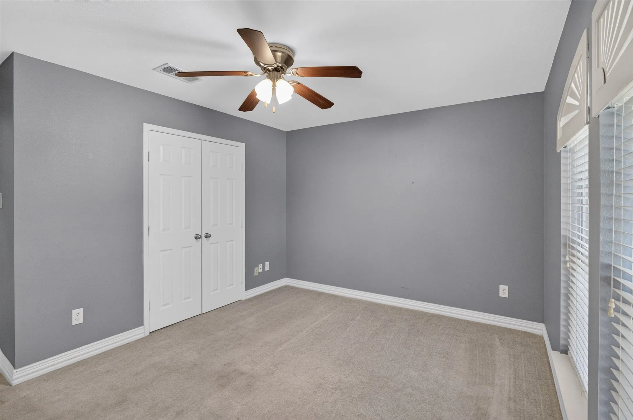 Interior room with light gray walls and light-toned carpet flooring