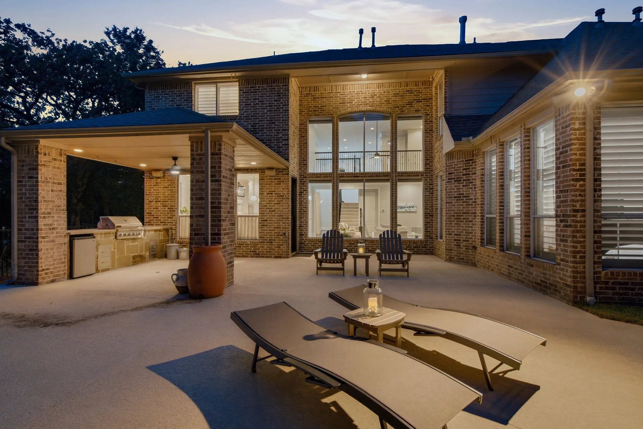Roomy entertaining space featuring a patio for lounge seating and built-in grill in the distance.