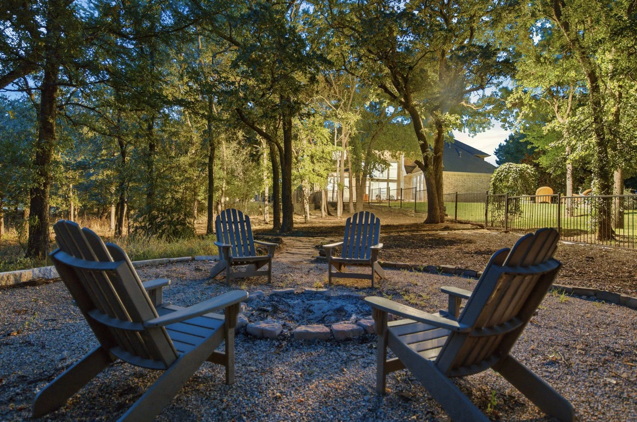 Fire Pit and seating off in the distance with a view back up to the back of the home.