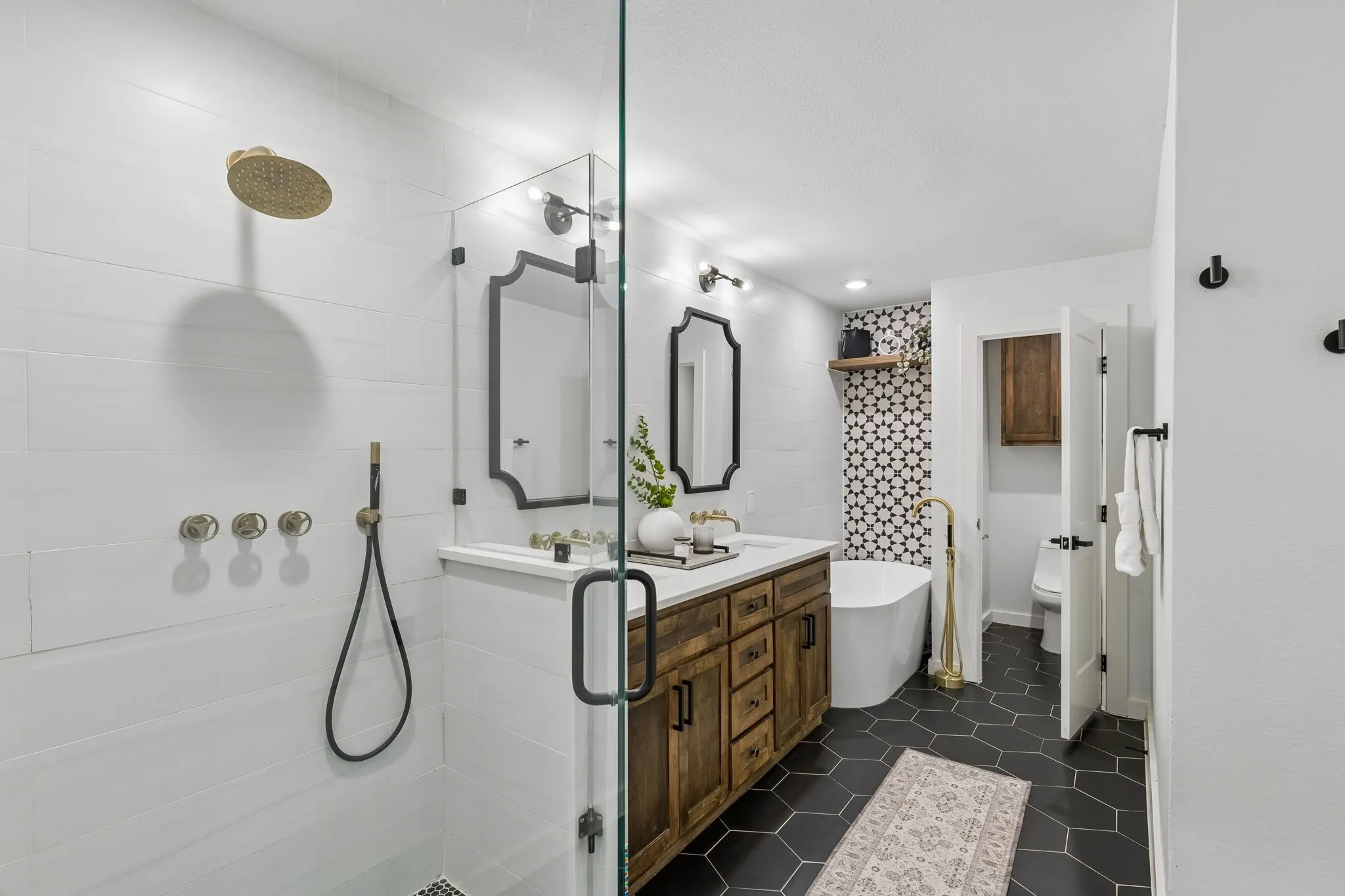 Glass-enclosed shower with wall-mounted fixtures