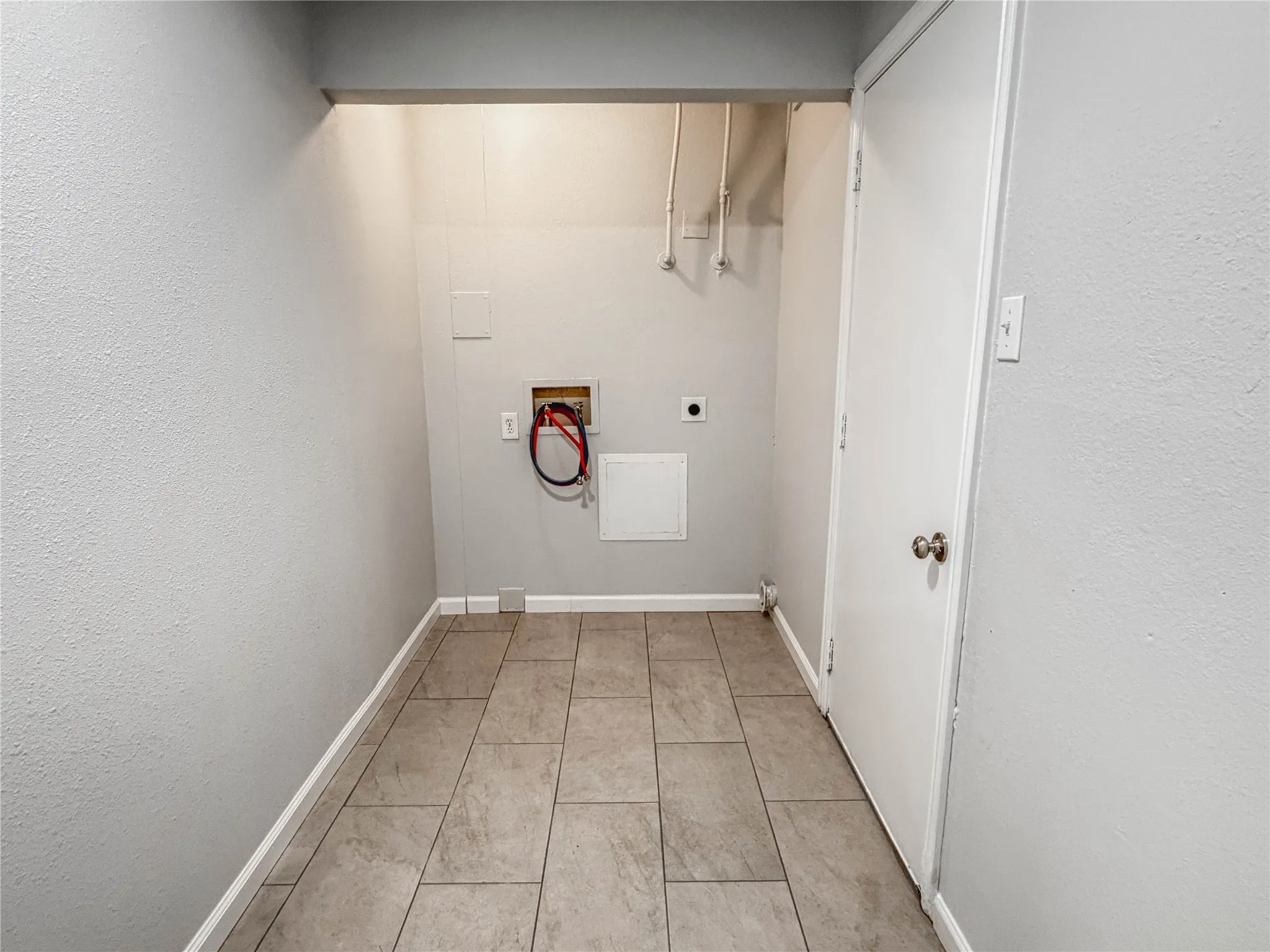 Laundry area featuring neutral wall tones and tile flooring
