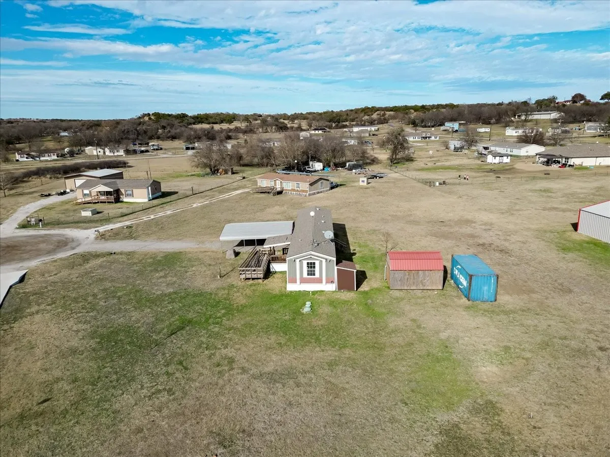 Expansive lot featuring a single-story residence with covered parking and additional storage structures